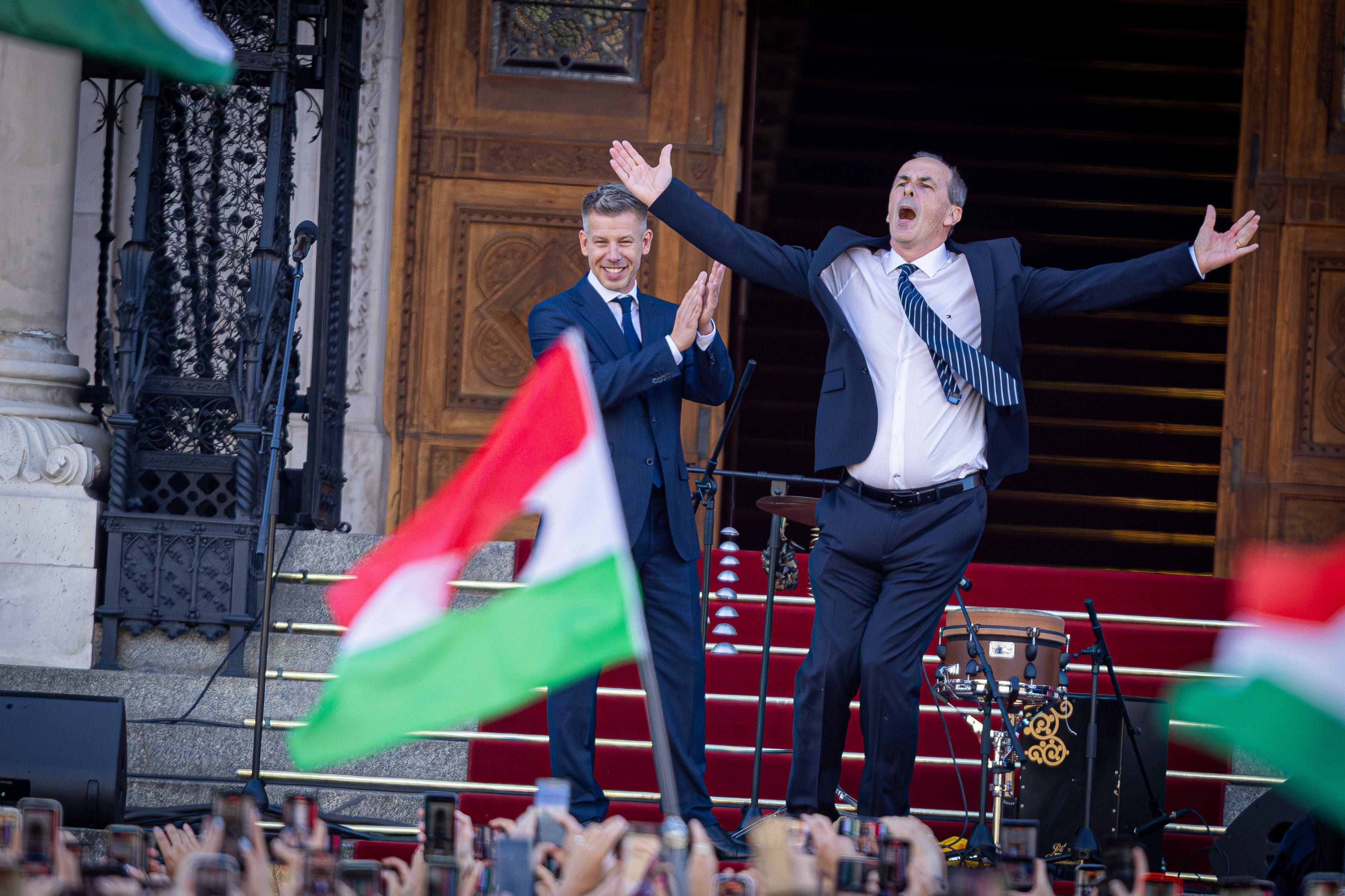 Zsolt Hegedűs tanzt am 9. Mai vor dem ungarischen Parlament. Links Ministerpräsident Péter Magyar