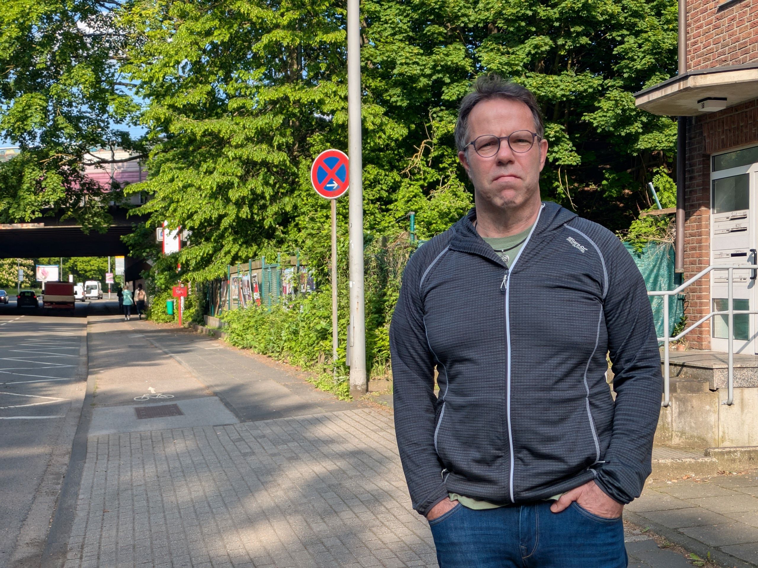 Ein Mann steht am Rand einer Straße.