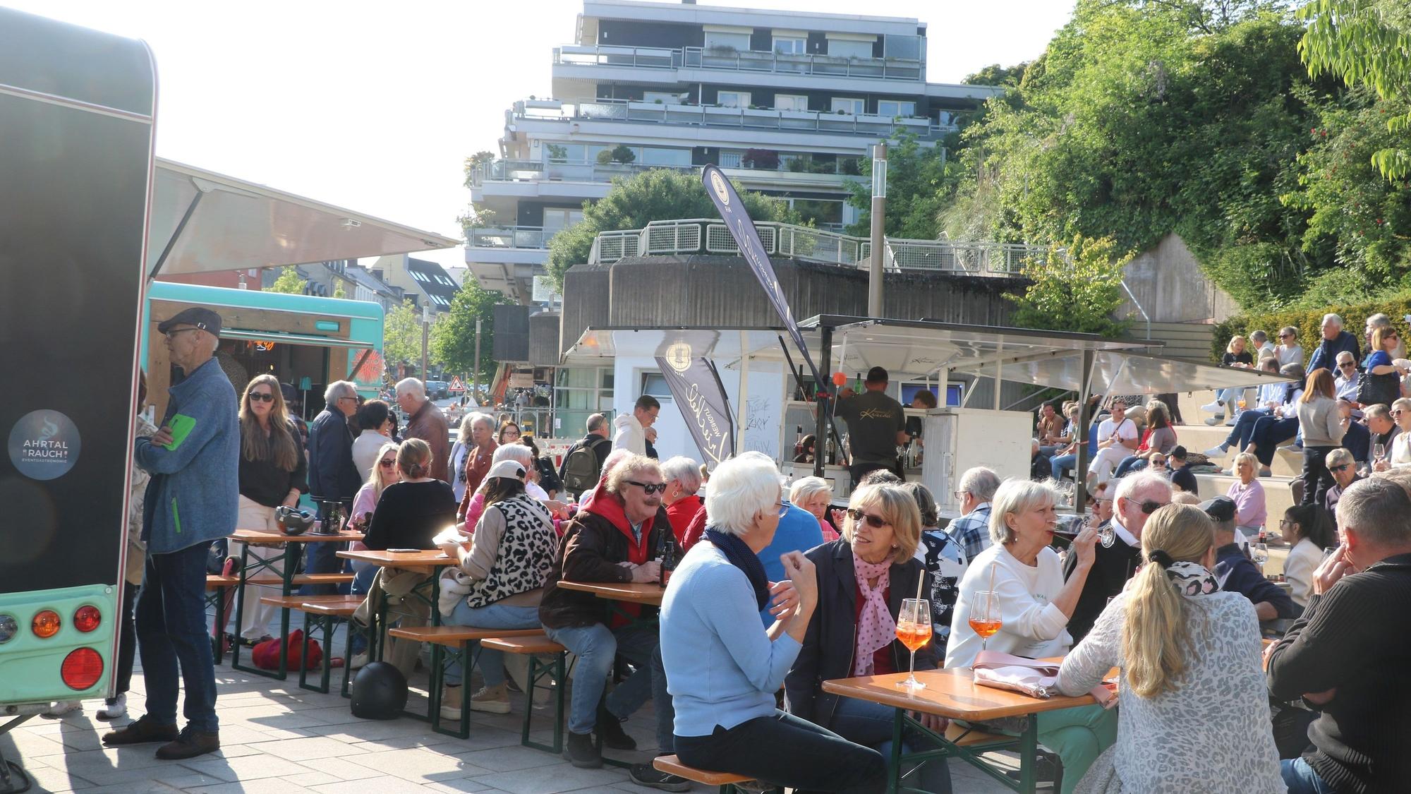 Menschen sitzen an Biertischen.