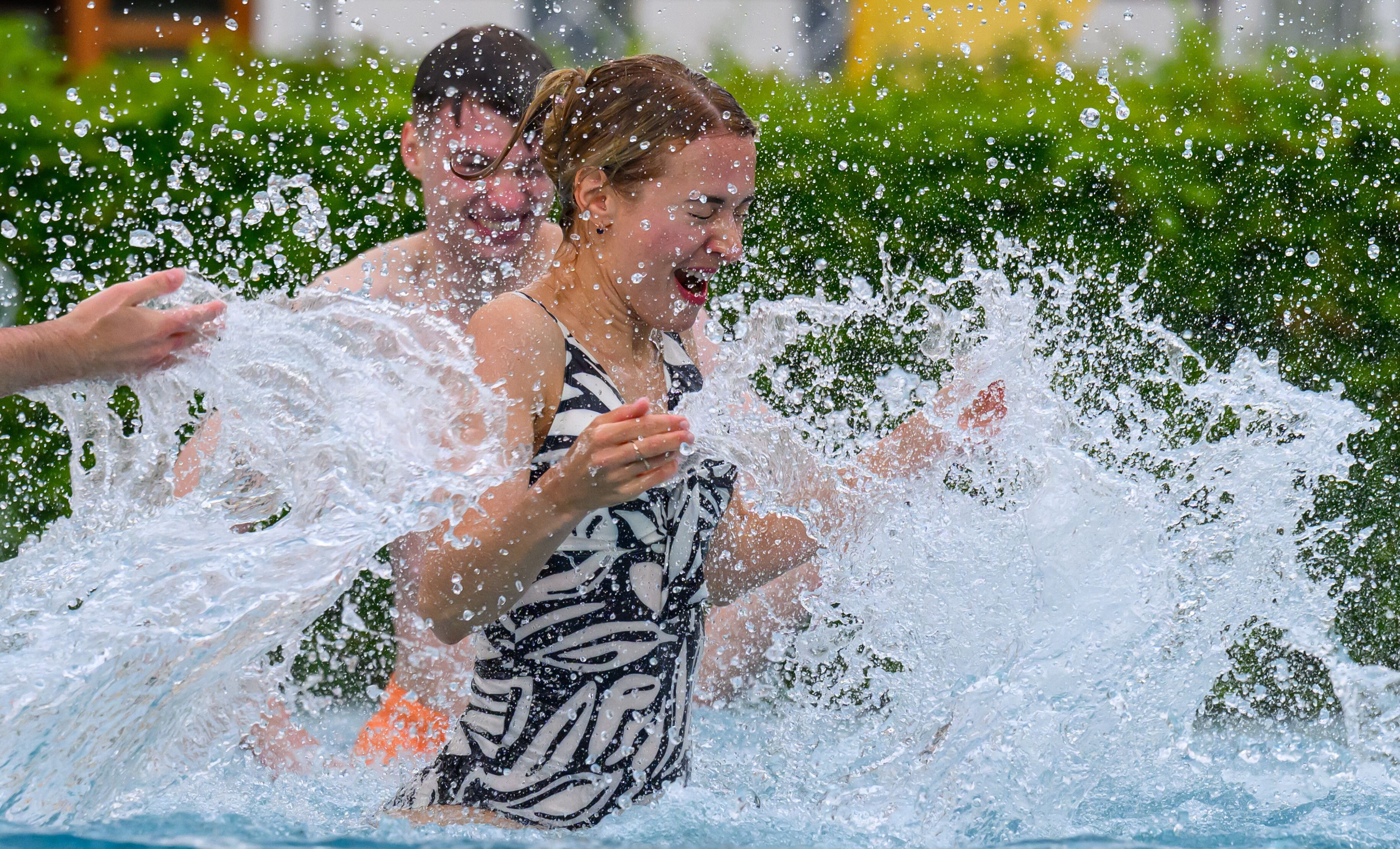 Badegäste planschen in einem Freibad im Wasser (Symbolfoto).