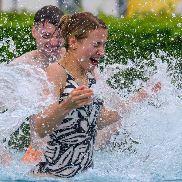 Badegäste planschen in einem Freibad im Wasser (Symbolfoto).