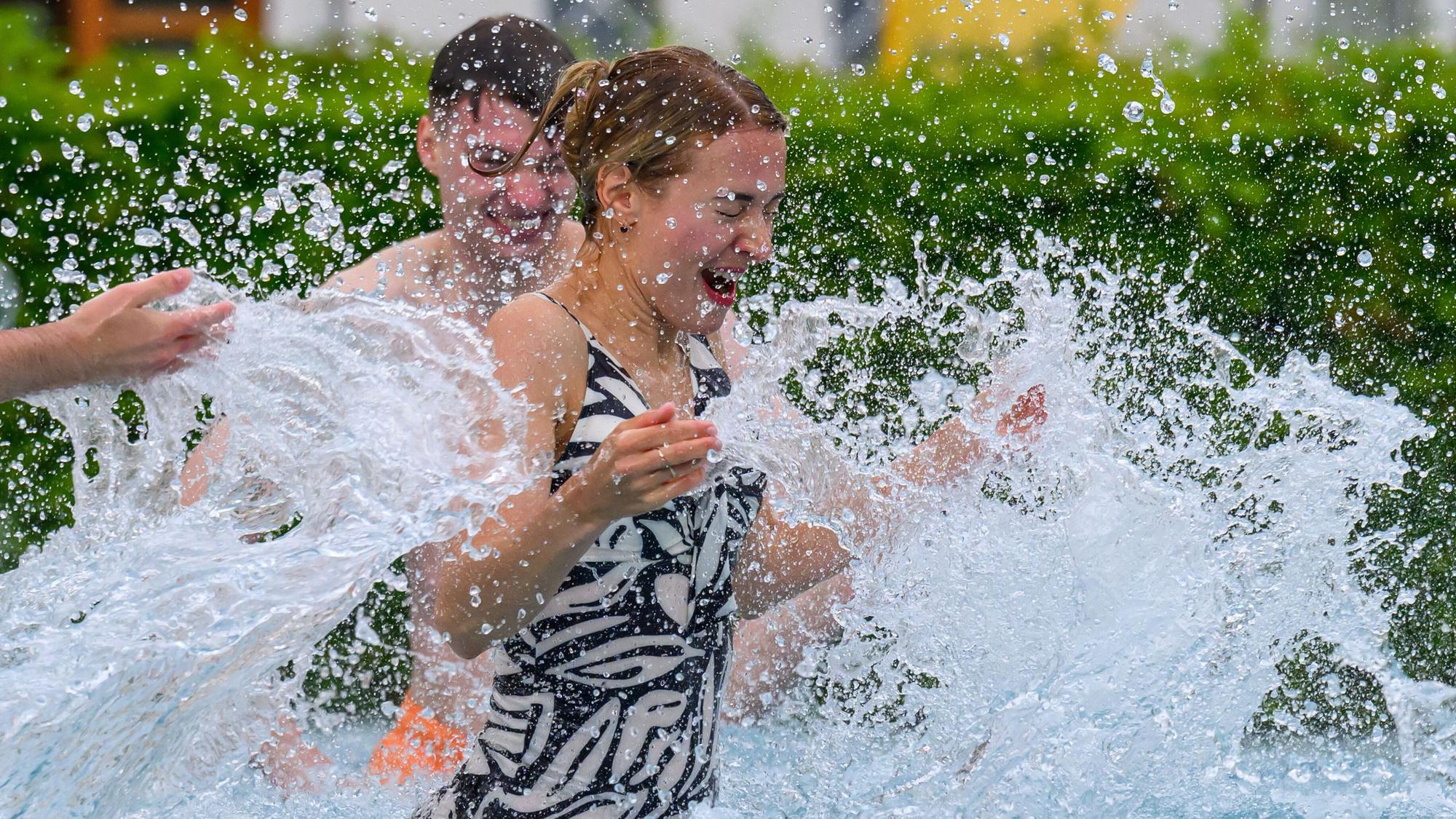 Badegäste planschen in einem Freibad im Wasser (Symbolfoto).