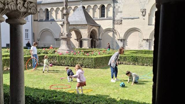 Das Foto zeigt spielende Kinder im Klostergarten der Abtei Brauweiler.