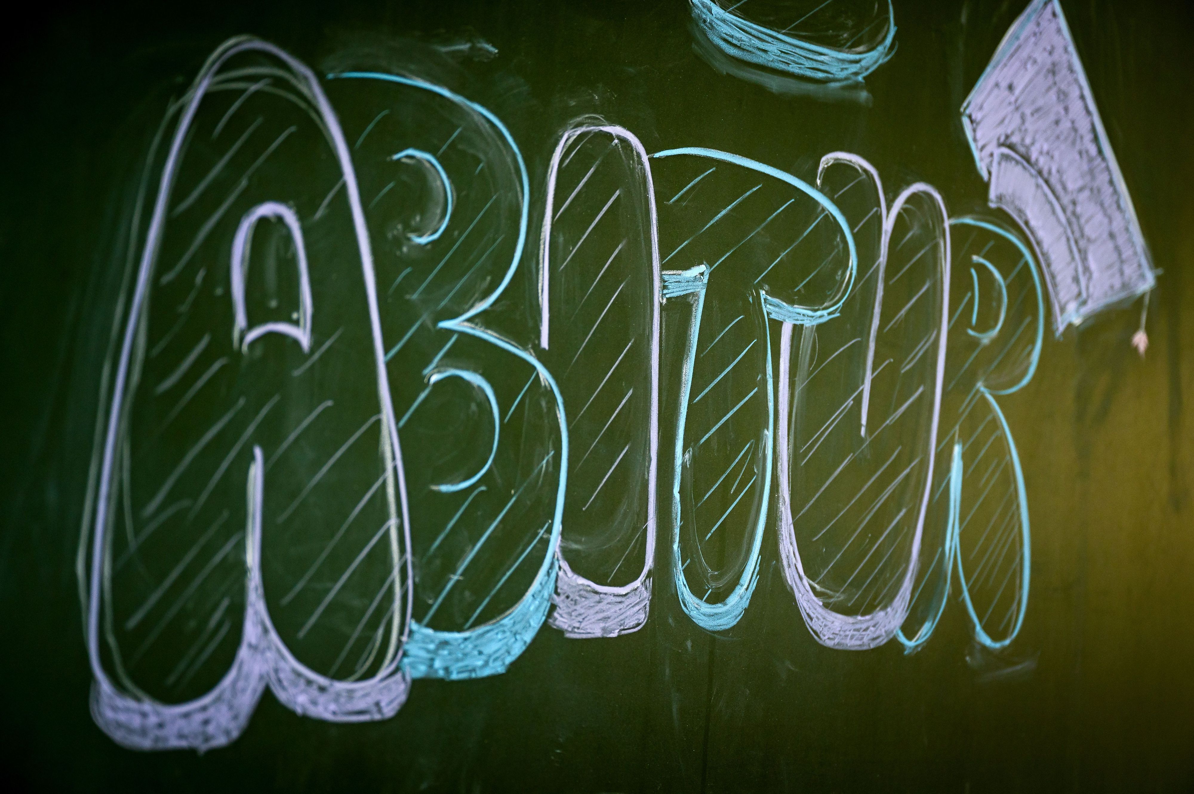 „Abitur“ steht auf einer Tafel im Klassenzimmer eines Gymnasiums. (Symbolbild)