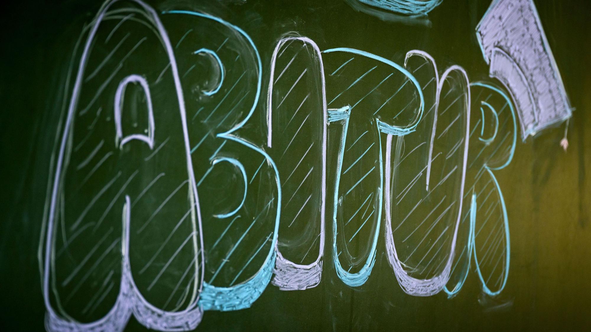 „Abitur“ steht auf einer Tafel im Klassenzimmer eines Gymnasiums. (Symbolbild)