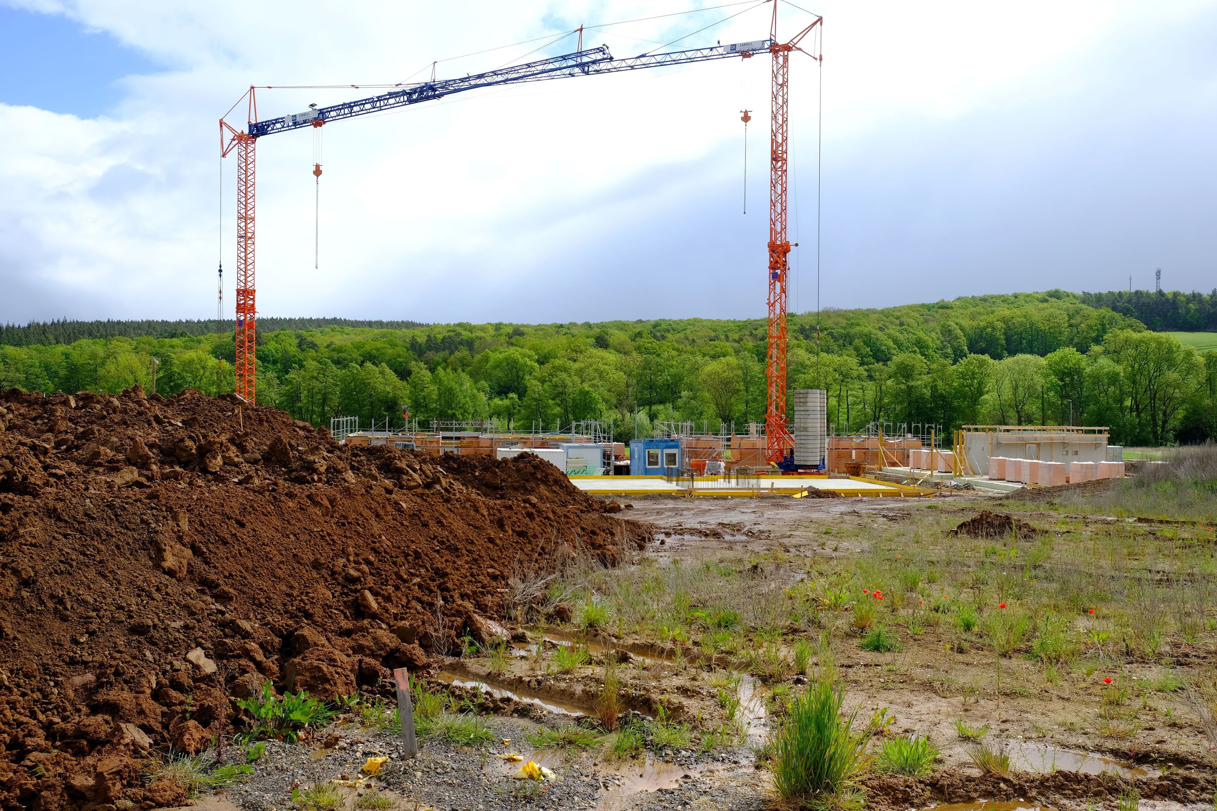 Im Baugebiet Auf der Wäsche in Mechernich sind die Arbeiten für eine umfangreiche Mehrfamilienhausbebauung angelaufen. An einer Baustelle sind zwei Kräne zu sehen.