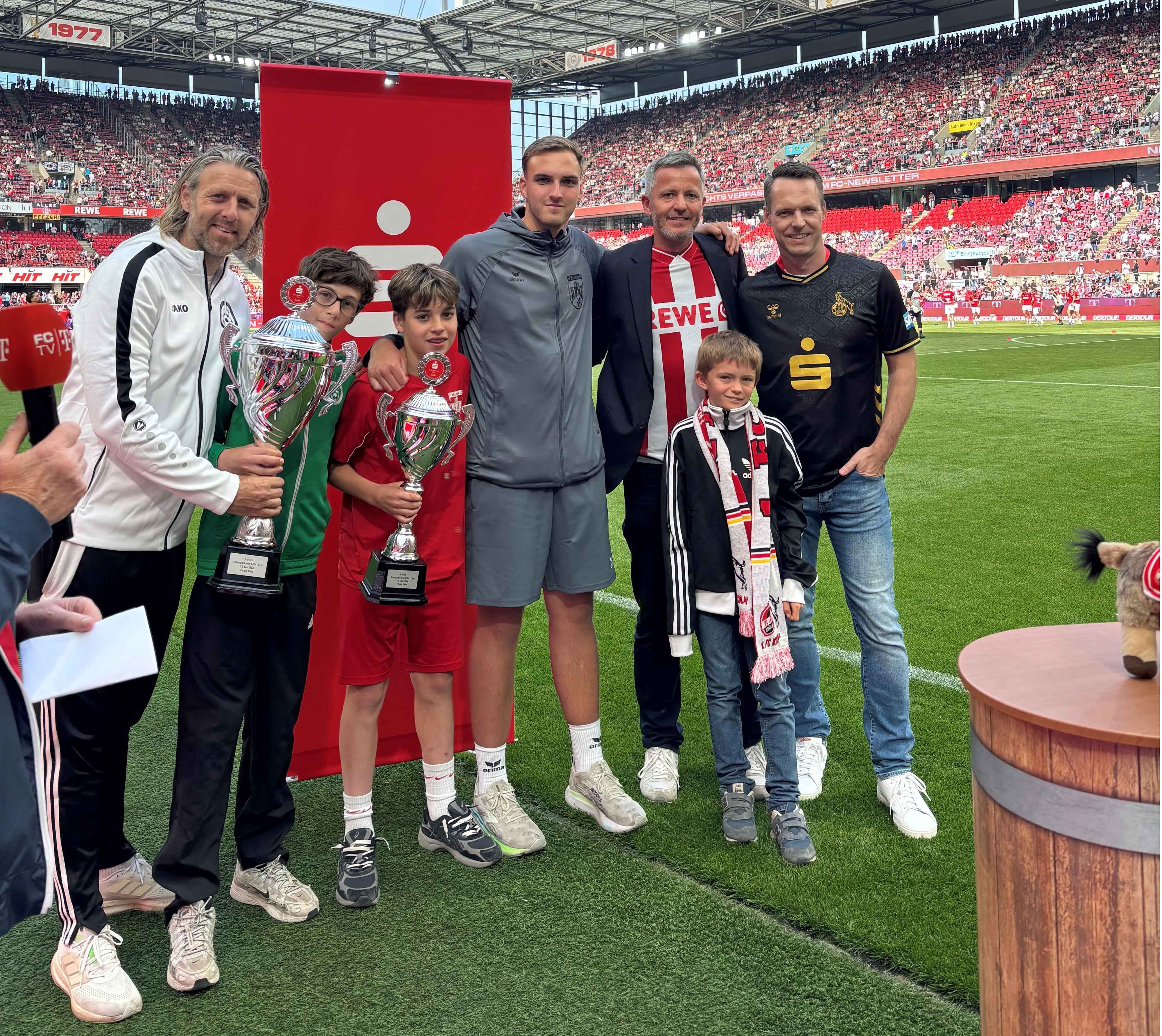Marco Steinbach, Vorstandsmitglied der Kreissparkasse Köln, und Philipp Liesenfeld, Geschäftsführer des 1. FC Köln (von rechts), überreichten die Pokale an Spielführer und Trainer der beiden Finalisten.