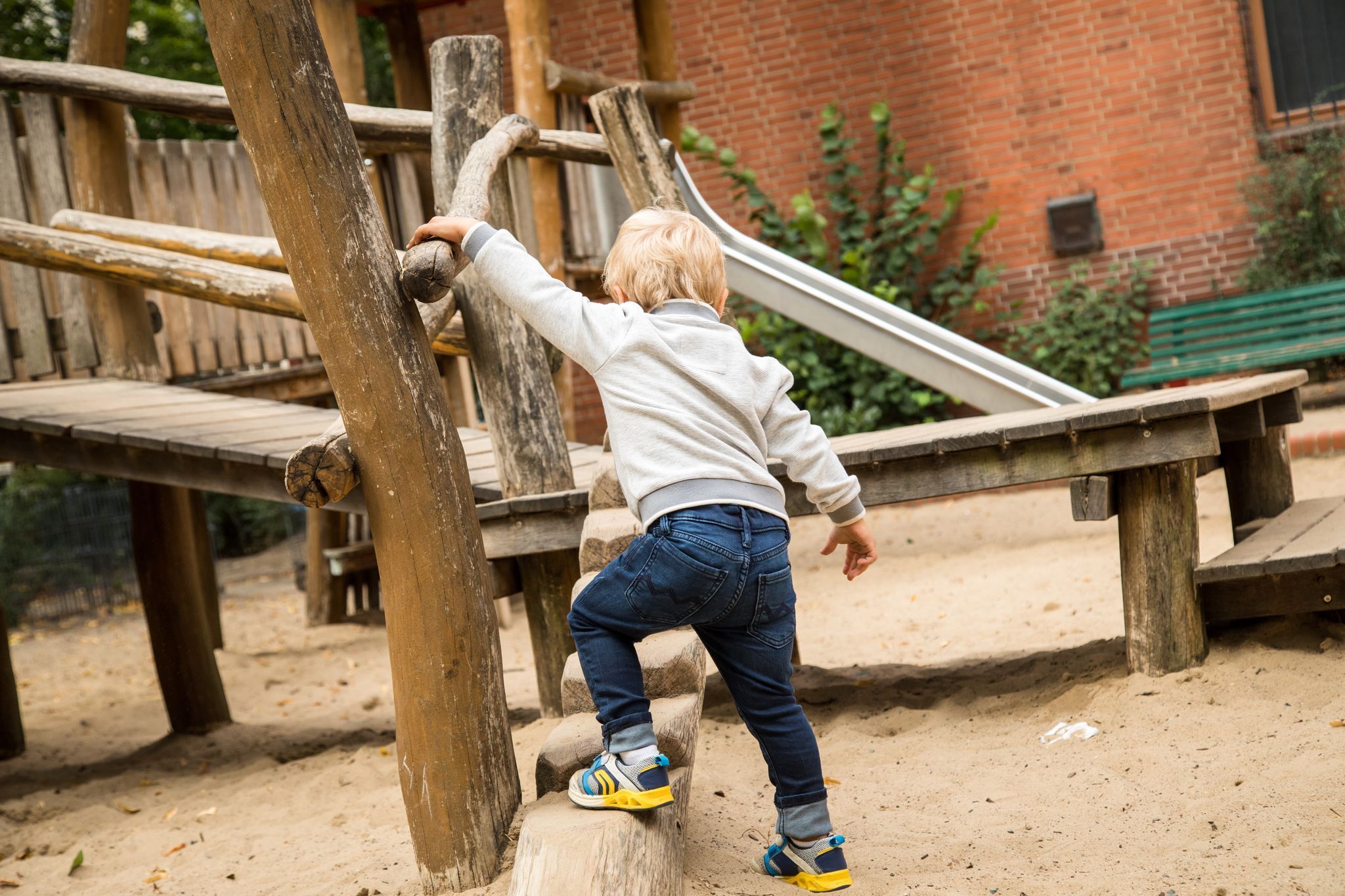 Junge spielt auf einem Spielplatz