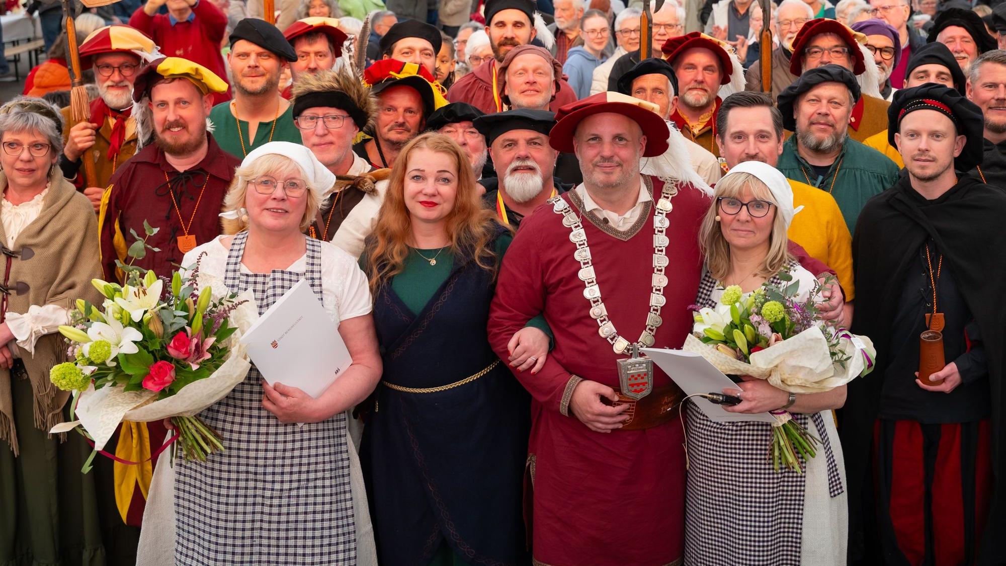 Zu sehen ist die Ehrung von zwei Frauen durch den Bürgermeister, umringt von den Landsknechten und Marketenderinnen der Stadt Bergneustadt.
