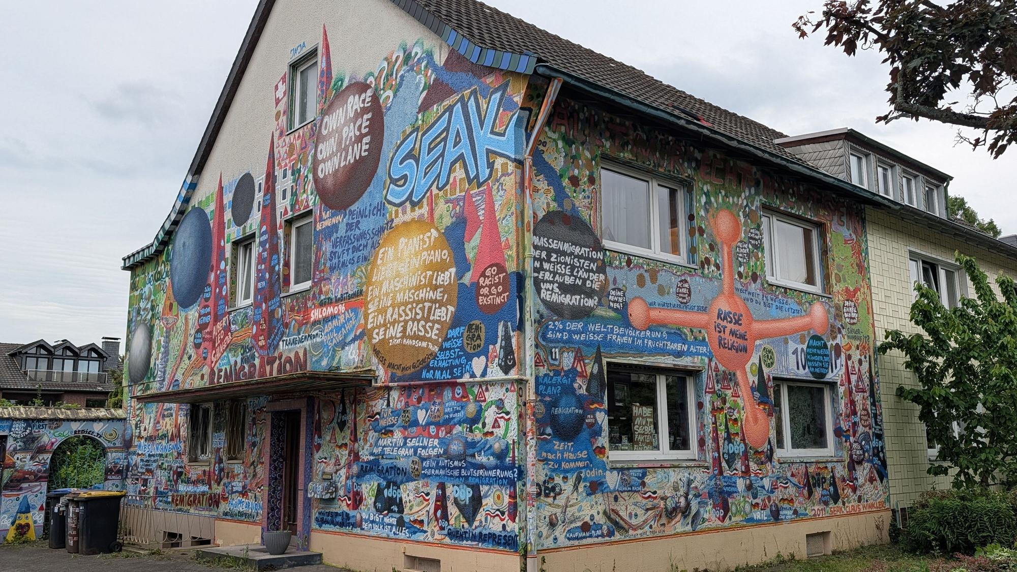 Das Foto zeigt das Haus mit seinen bunt bemalten Fassaden.