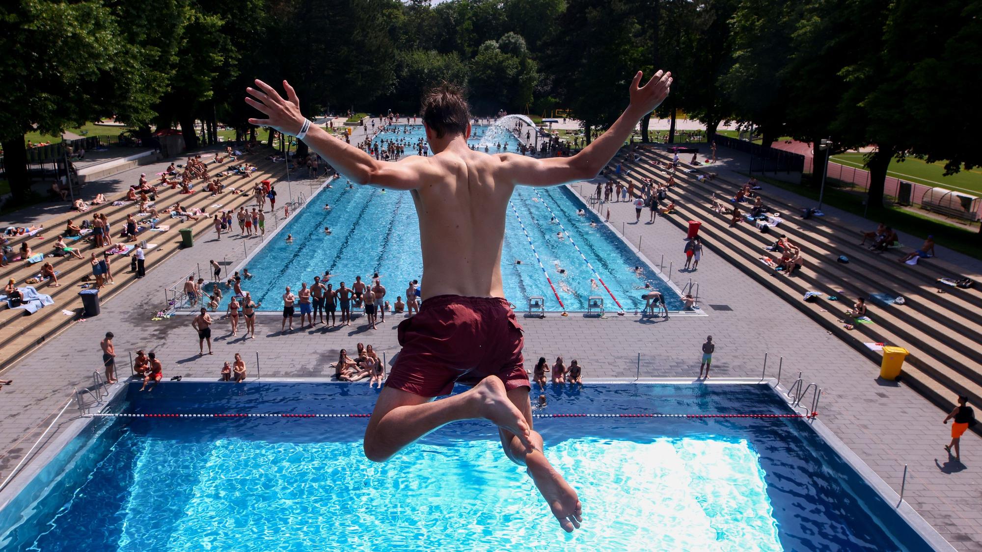 Ein junger Mann springt im Stadionbad in Köln vom 10-Meter-Turm.
