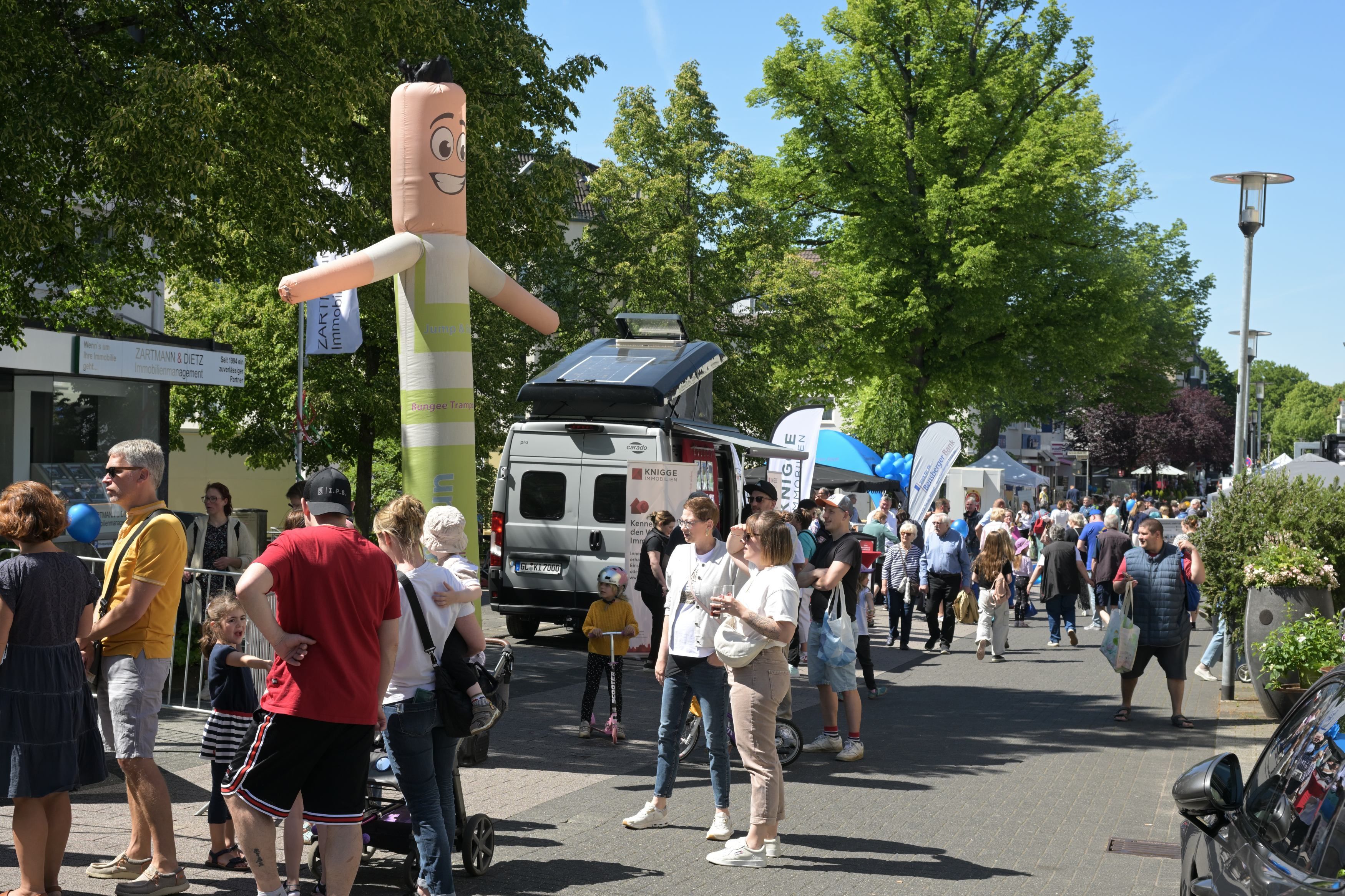 Menschen gehen an Ständen vorbei.
