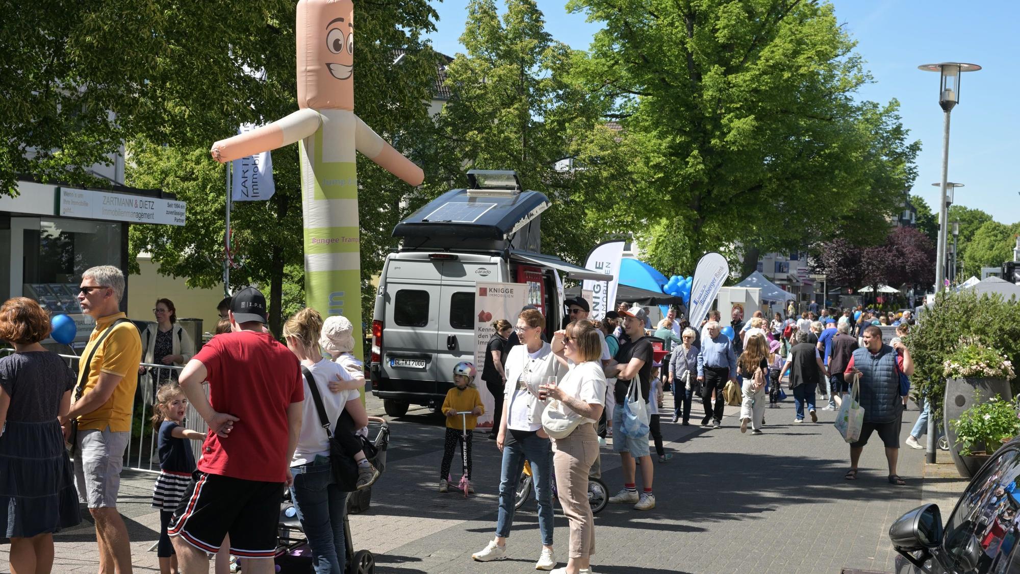 Menschen gehen an Ständen vorbei.
