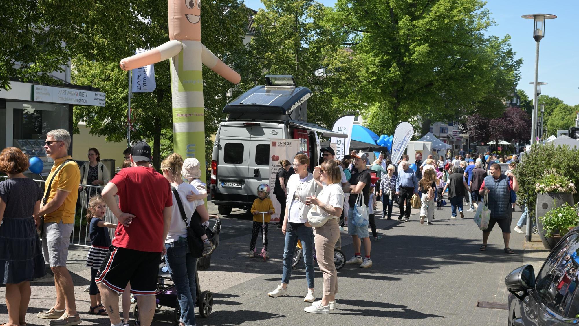 Menschen stehen vor Ständen.