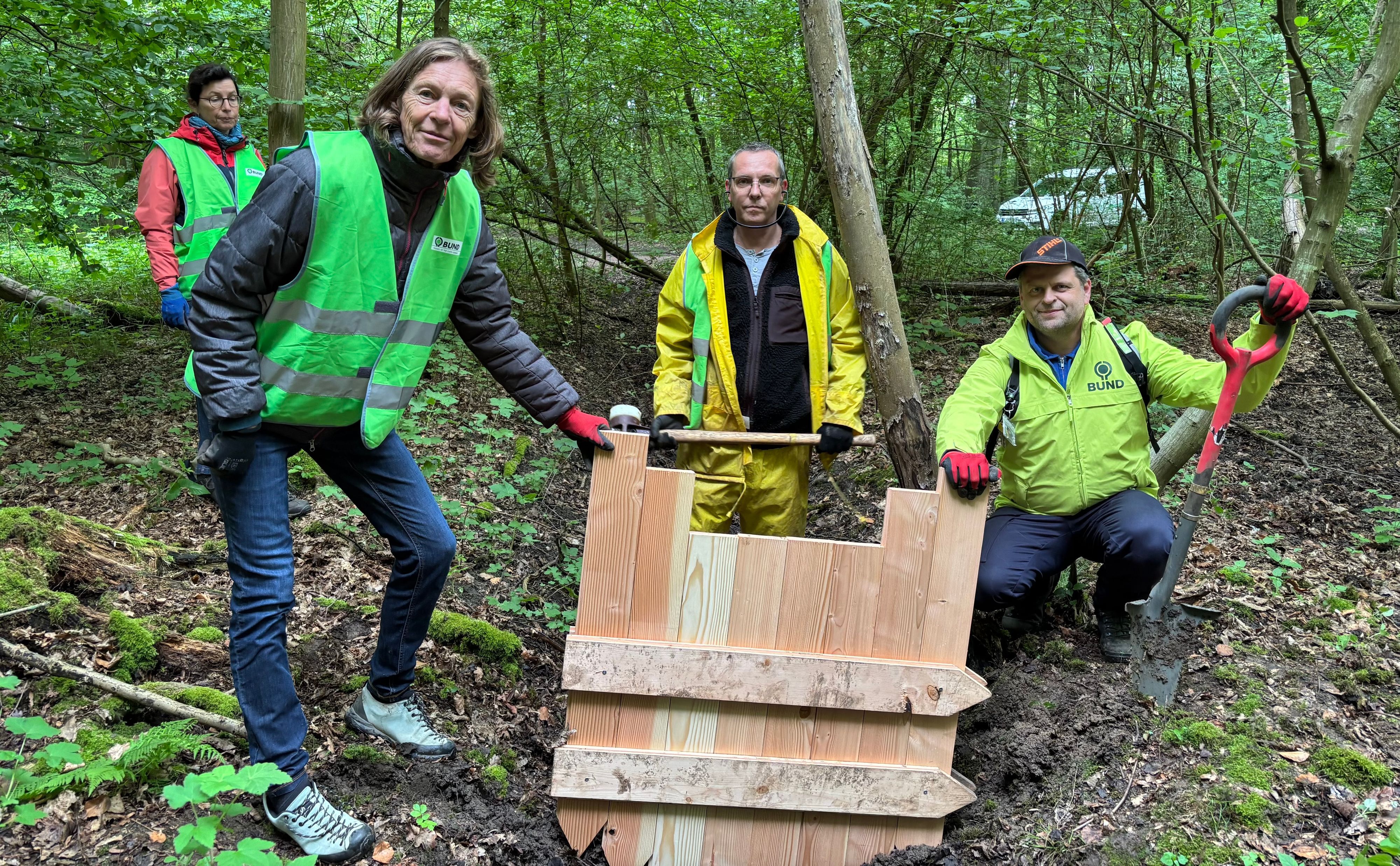 Der BUND renaturiert Moore. Dr. Maritn Grund (2.v.r.) koordiniert das Projekt. Hier wird eine Spuntwand in einen Entwässerungsgraben eingelassen.