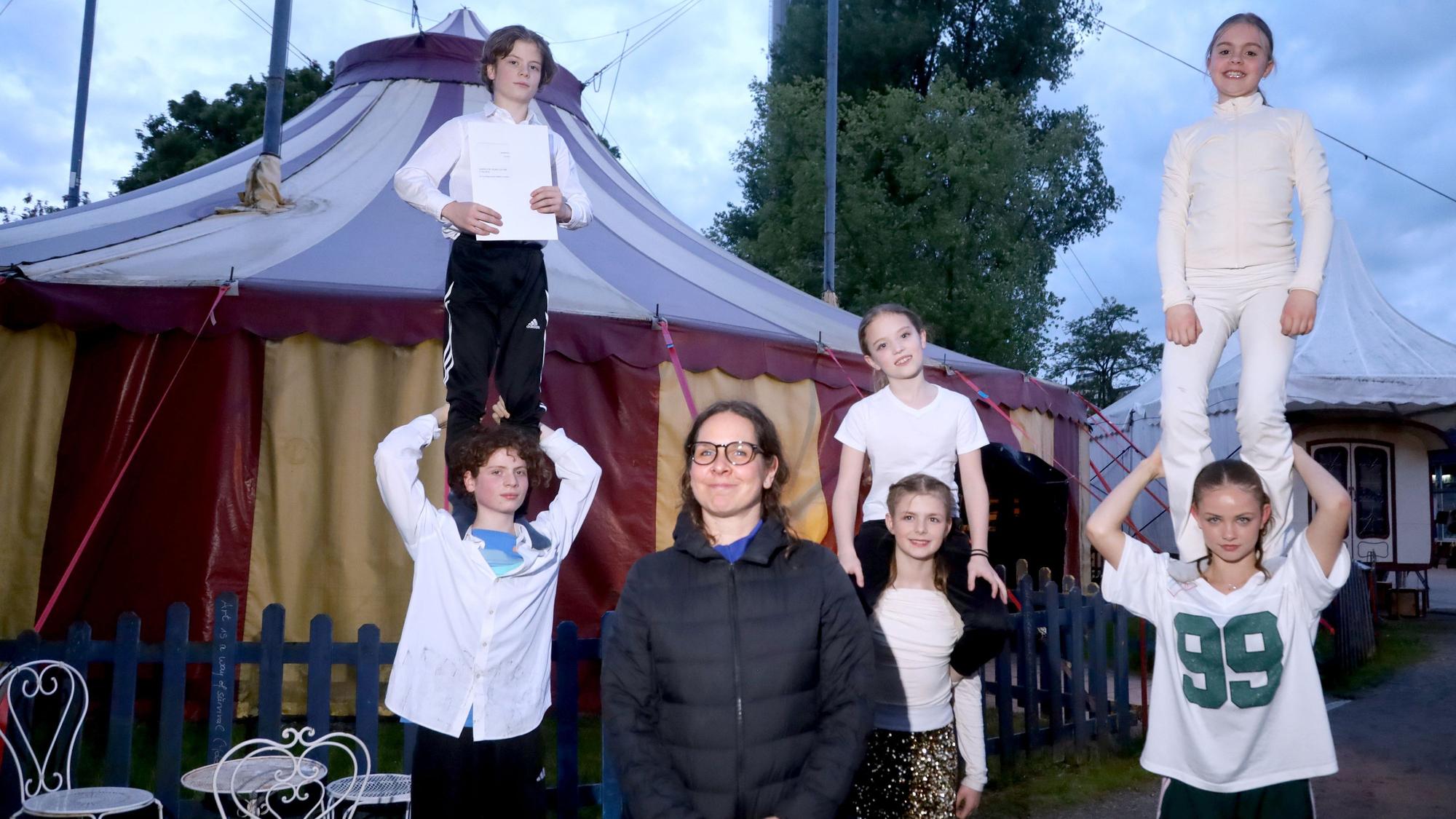 Éva Adorján steht mit sechs Kindern, die Figuren formen, vor dem Zelt von Latibul.