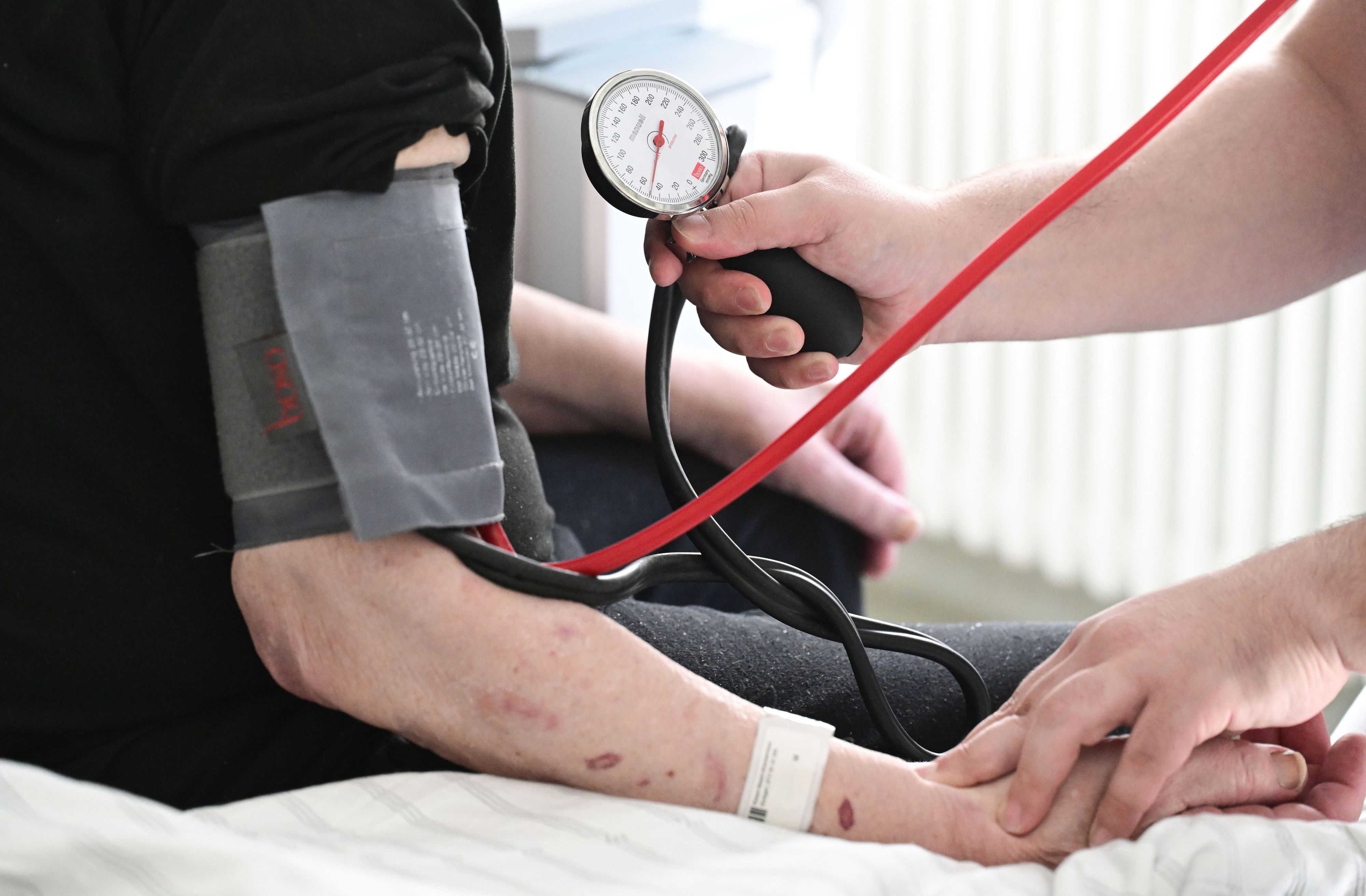 ARCHIV - 08.10.2025, Baden-Württemberg, Stuttgart: Ein Pfleger misst in einem Krankenhaus auf einer Station bei einem Patienten den Blutdruck. (zu dpa: «Statistik: Mehr Pflegeazubis im Südwesten tätig») Foto: Bernd Weißbrod/dpa +++ dpa-Bildfunk +++
