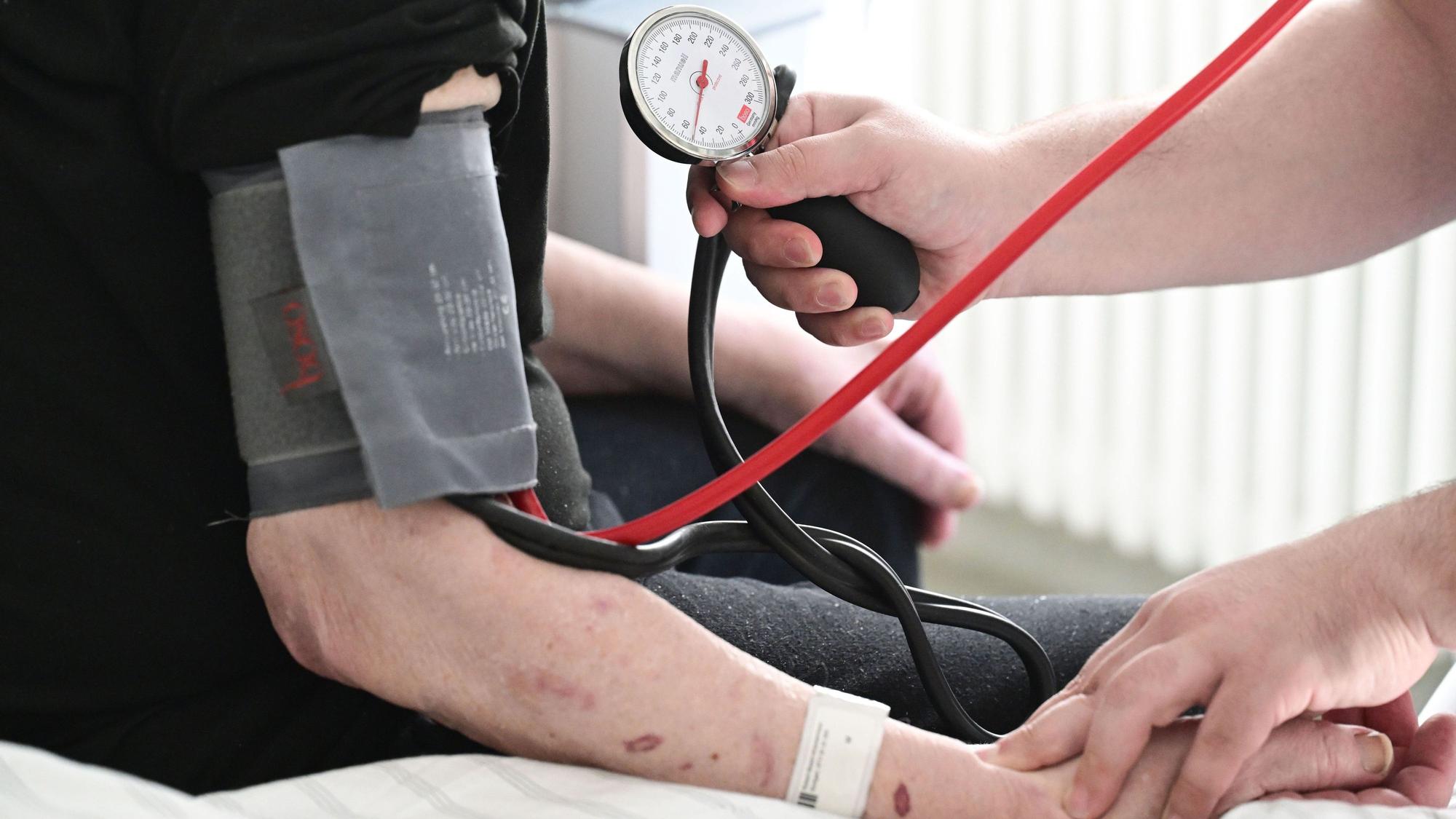 ARCHIV - 08.10.2025, Baden-Württemberg, Stuttgart: Ein Pfleger misst in einem Krankenhaus auf einer Station bei einem Patienten den Blutdruck. (zu dpa: «Statistik: Mehr Pflegeazubis im Südwesten tätig») Foto: Bernd Weißbrod/dpa +++ dpa-Bildfunk +++