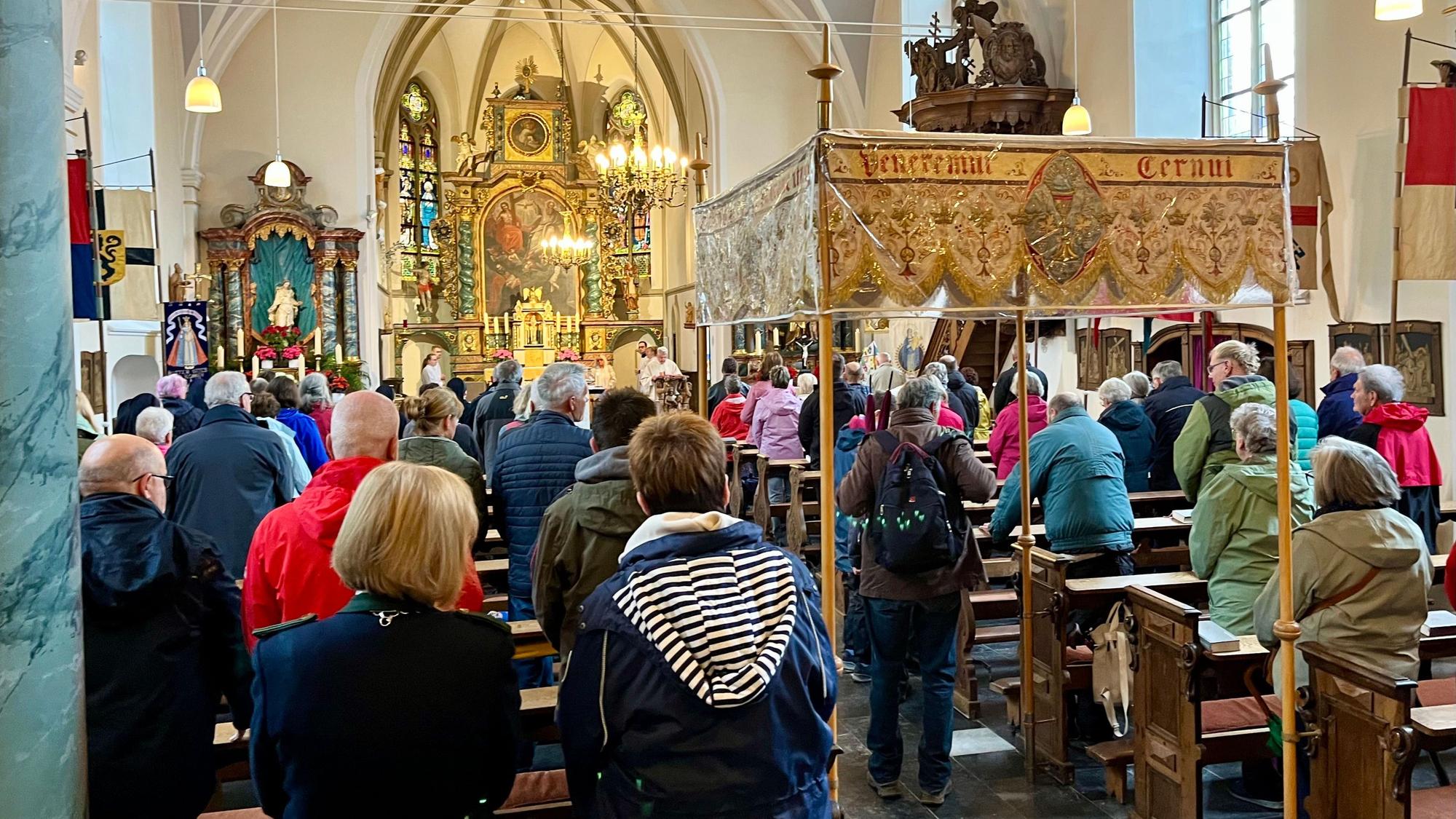 Menschen stehen in einer Kirche.