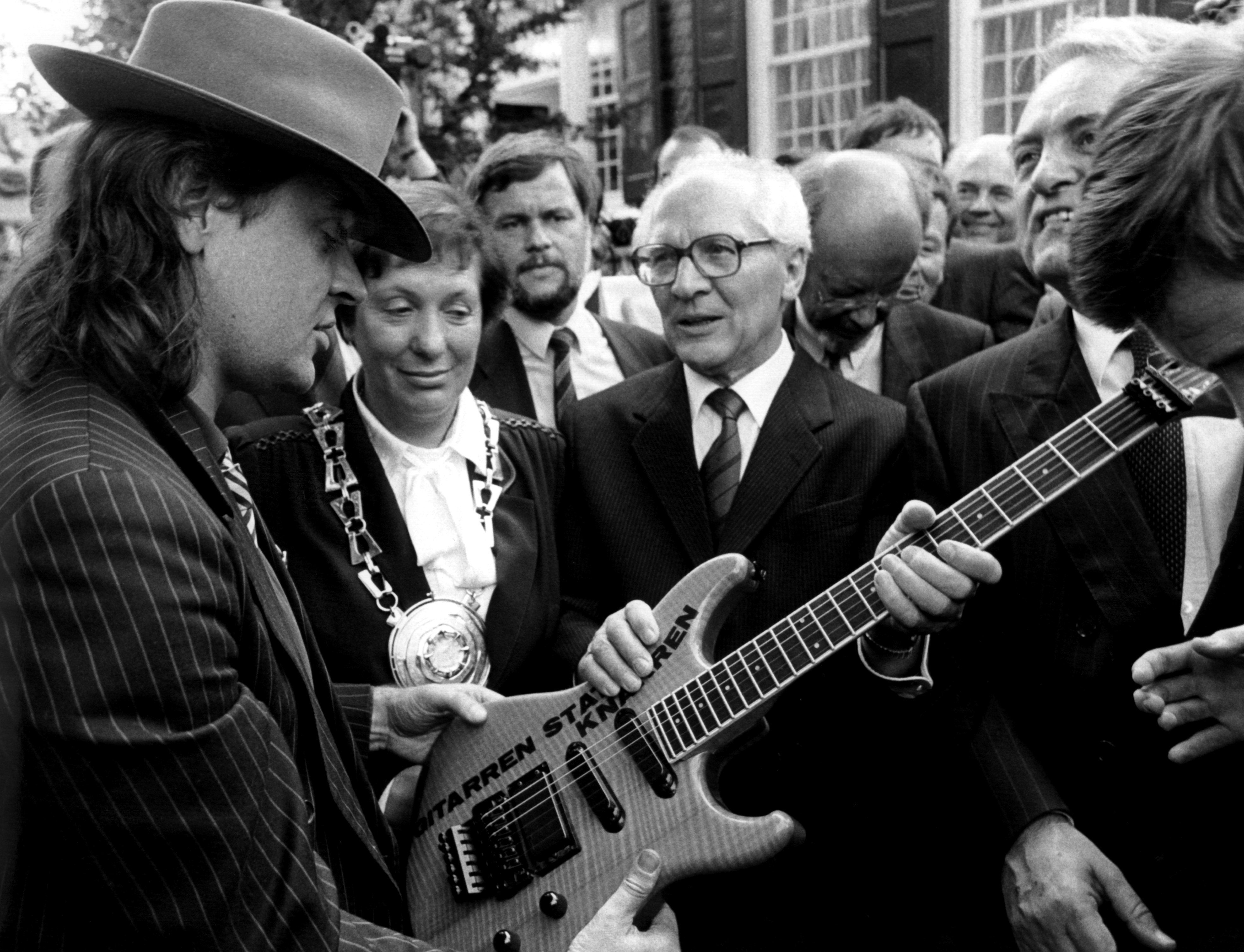 ARCHIV - 09.09.1987, Nordrhein-Westfalen, Wuppertal: Rockmusiker Udo Lindenberg (l) überreicht dem ehemaligen SED-Generalsekretär Erich Honecker (M) eine Gitarre mit der Aufschrift «Gitarren statt Knarren». (zu dpa: ««Panikrocker» Udo Lindenberg: In 80 Jahren um die Welt») Foto: Franz-Peter Tschauner/dpa +++ dpa-Bildfunk +++