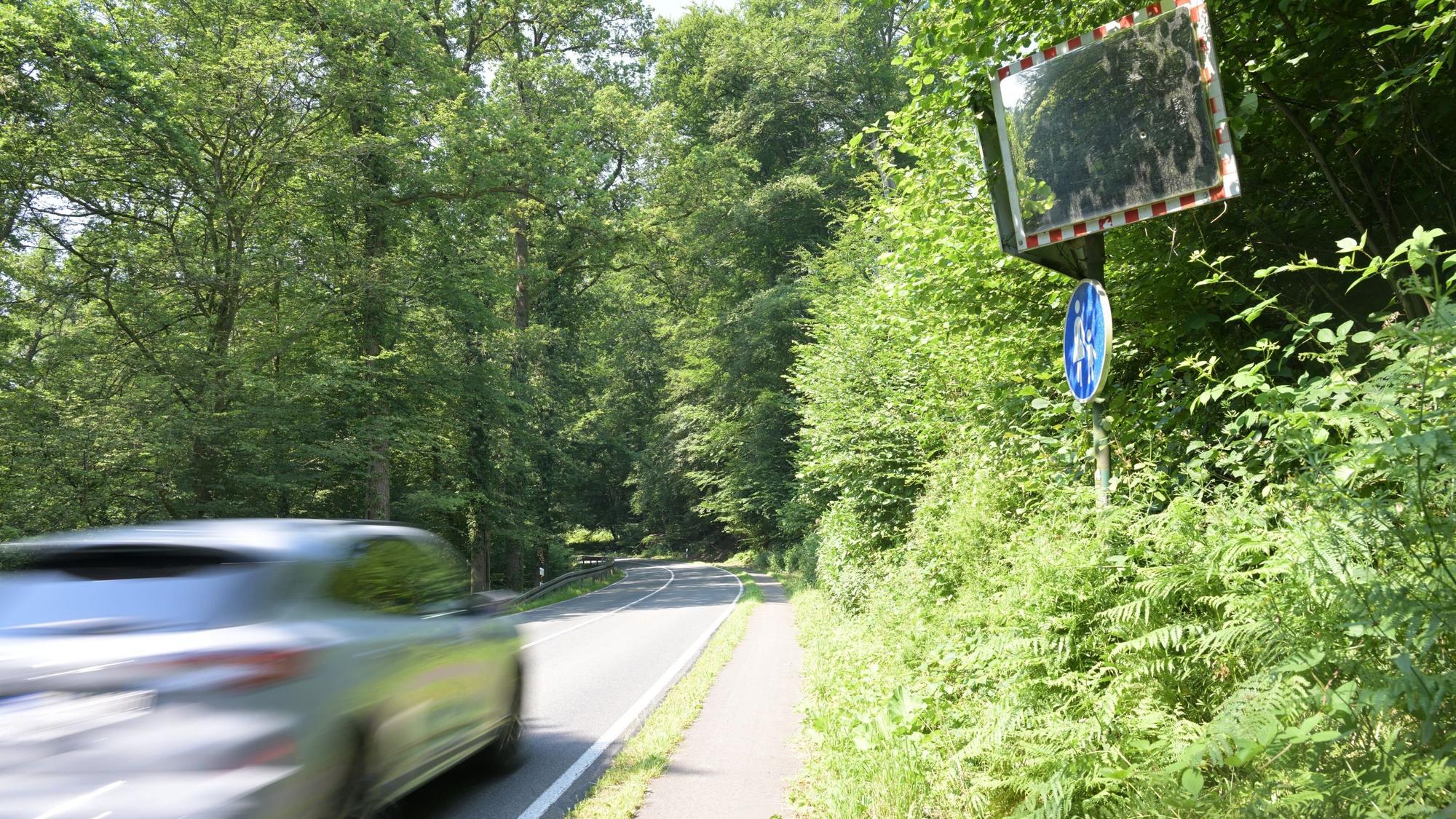 Ein Auto auf einer engen, unübersichtlichen Landstraße.