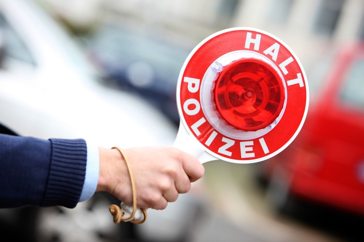 Eine Polizeikelle liegt auf dem Armaturenbrett eines Polizeiautos. (Symbolbild)