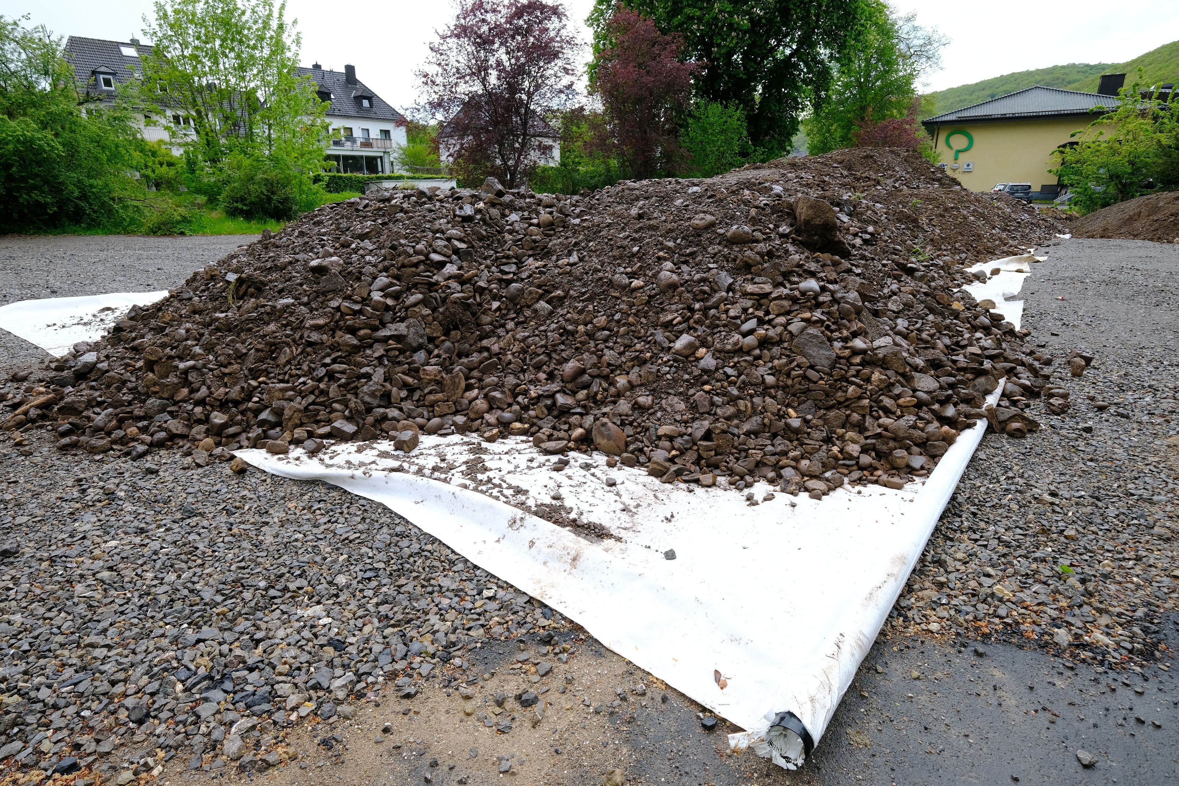 Erdaushub aus Olef und Urft wird auf dem Katharinenhof-Parkplatz in Gemünd auf einer weißen Plane zwischengelagert.