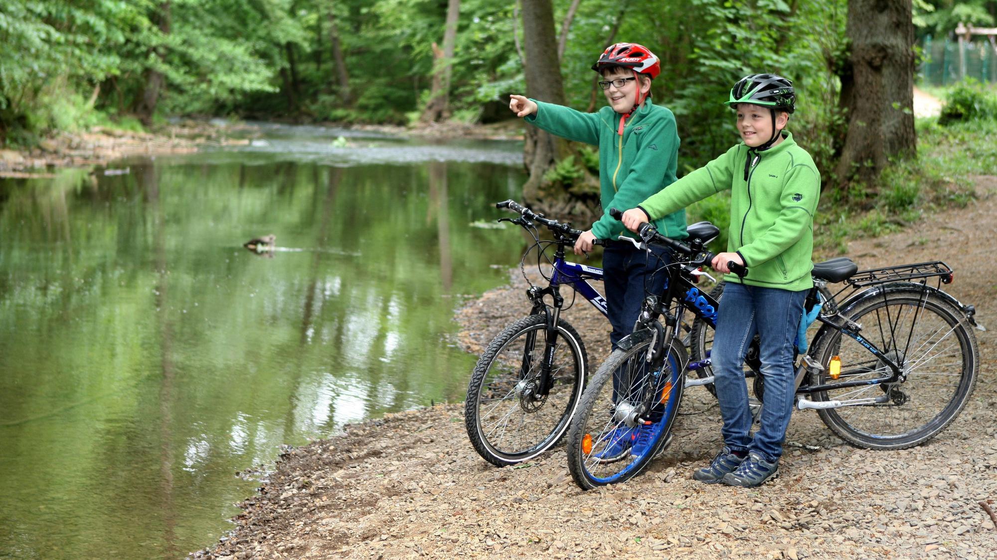 Zwei Kinder stehen mit ihren Fahrrädern an der Dhünn in Odenthal.