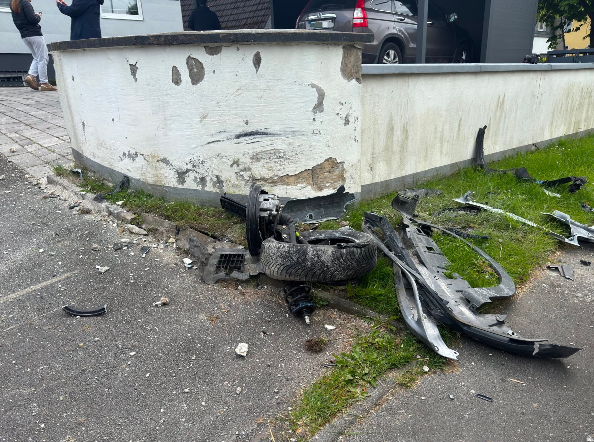 Bei dem Aufprall rissen Fahrzeugteile und ein Vorderrad ab, die Mauer wurde beschädigt.