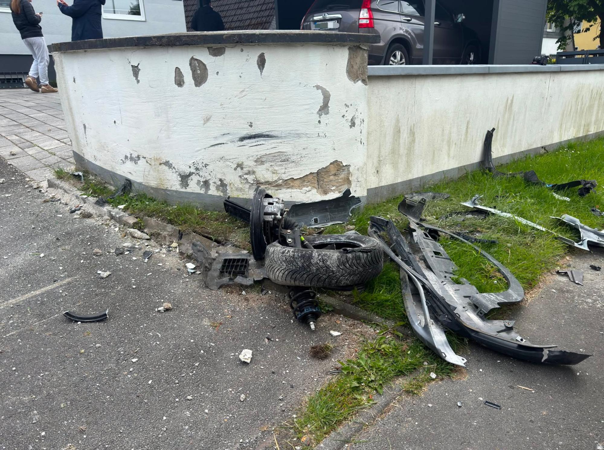 Bei dem Aufprall rissen Fahrzeugteile und ein Vorderrad ab, die Mauer wurde beschädigt.