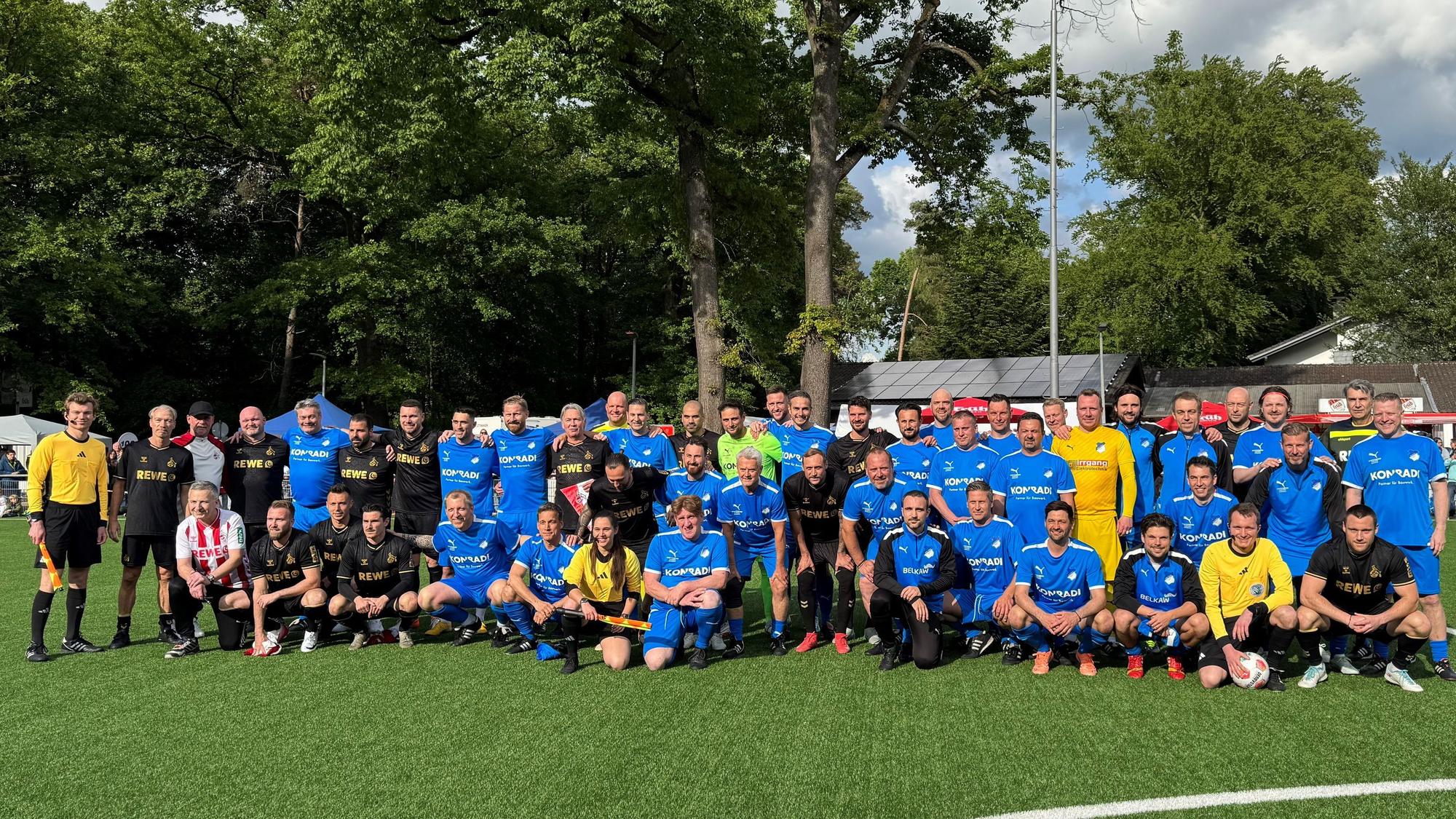 Gruppenbild von zwei Fußballteams in blauen und schwarzen Trikots