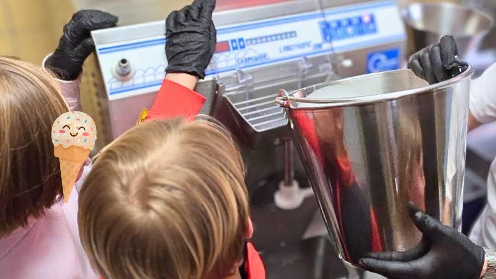 Zwei Kinder stehen vor einer Eismaschine. Ein Erwachsener hält einen Metalleimer, in den das Eis kommt.