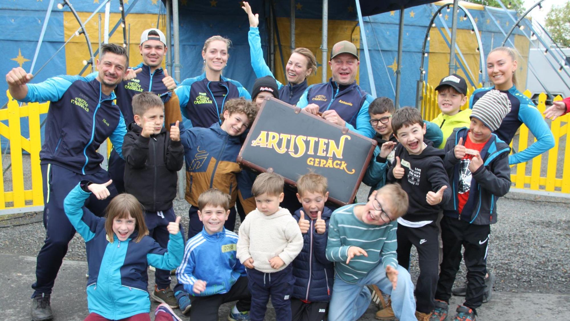 Kinder der Grundschule Dahlem stehen vor einem Zirkuszelt.