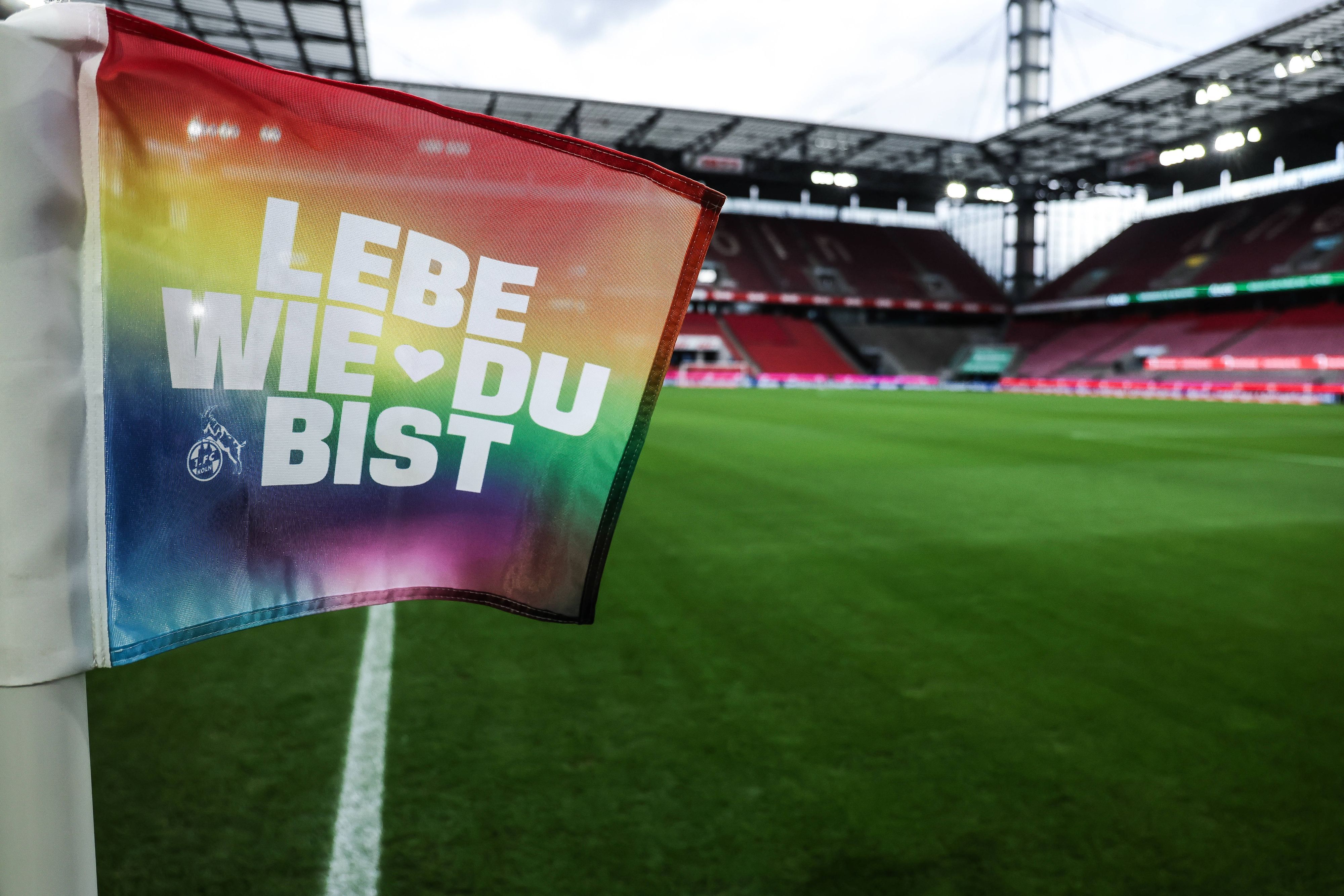 Eine Eckfahne in Regenbogenfarben mit der Aufschrift „Lebe wie du bist“ und dem Logo des 1. FC Köln steht im Rheinenergie-Stadion. (Archivbild)