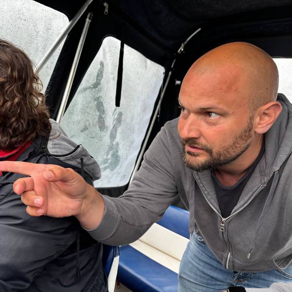 Ein Mann mit Glatze und Bart zeigt eine Richtung an.
