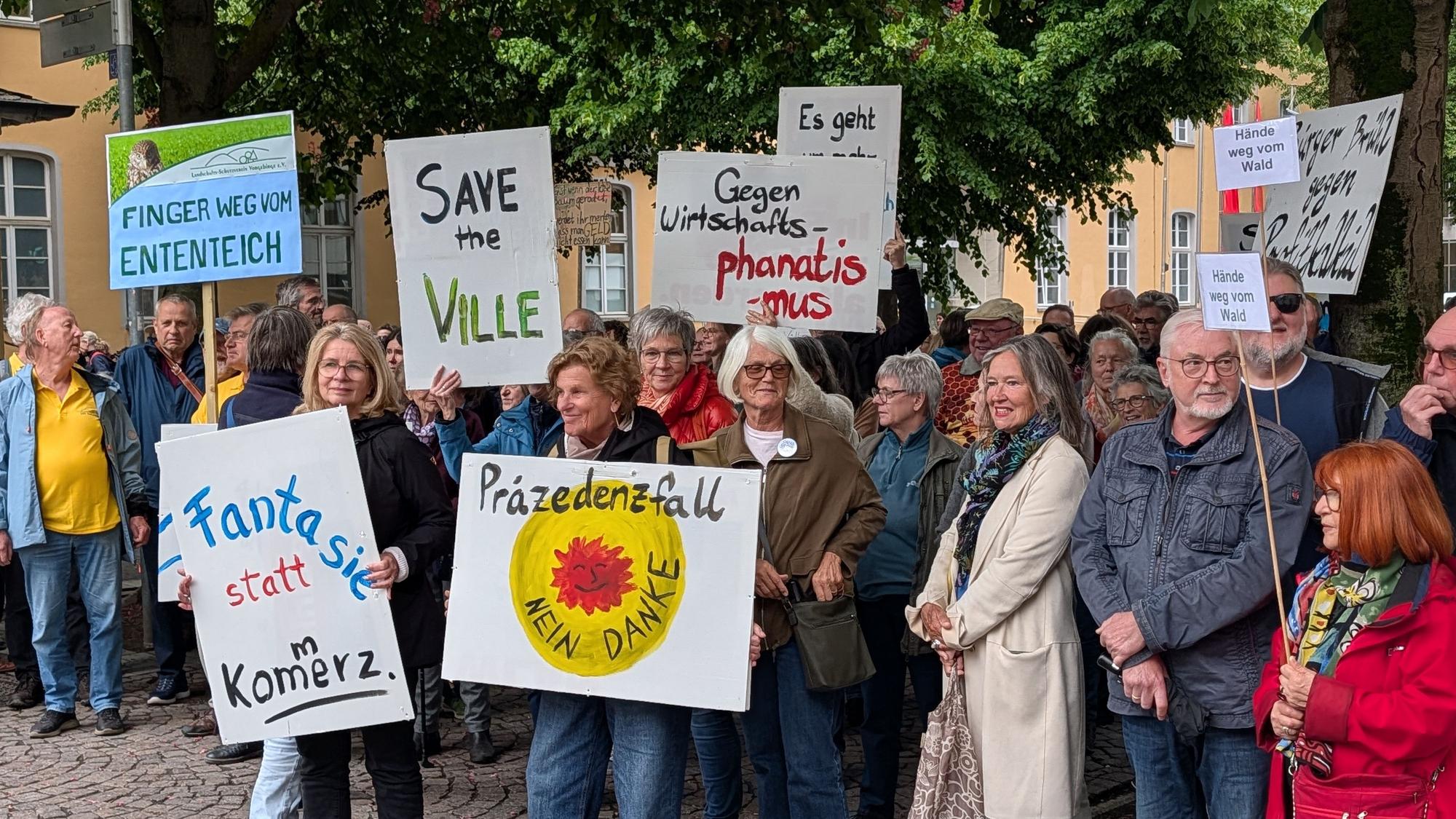 Das Foto zeigt Demonstranten mit Plakaten in der Brühler Innenstadt.