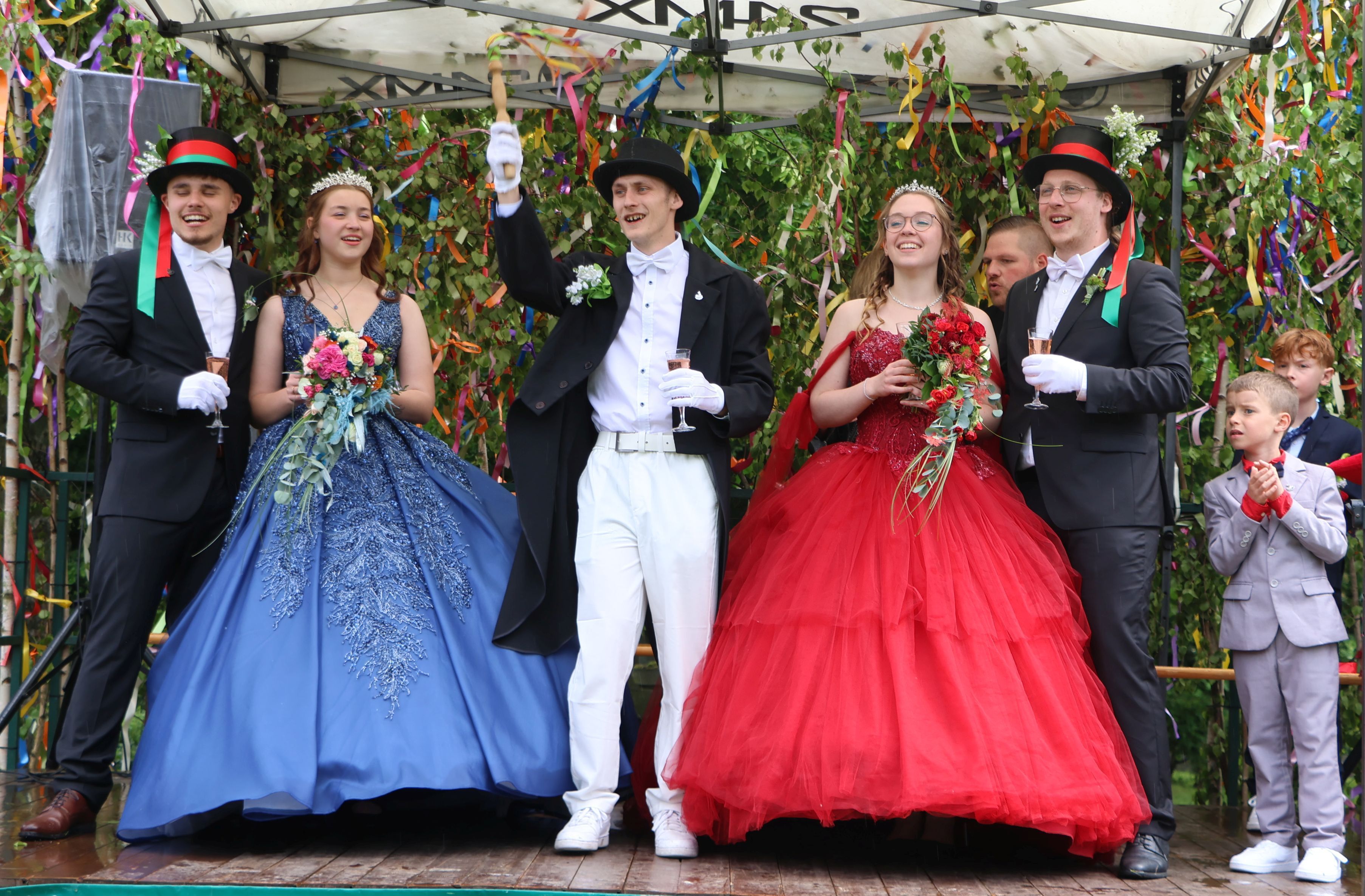 Das Wetter spielte nicht richtig mit, aber den Grefrather Maipaaren war das egal, die Stimmung war prächtig: Cedric Cöllen und Charlotte Wünsch, Sebastian Camus, Alina Sandmann und Tim Reum genossen ihre Krönung.