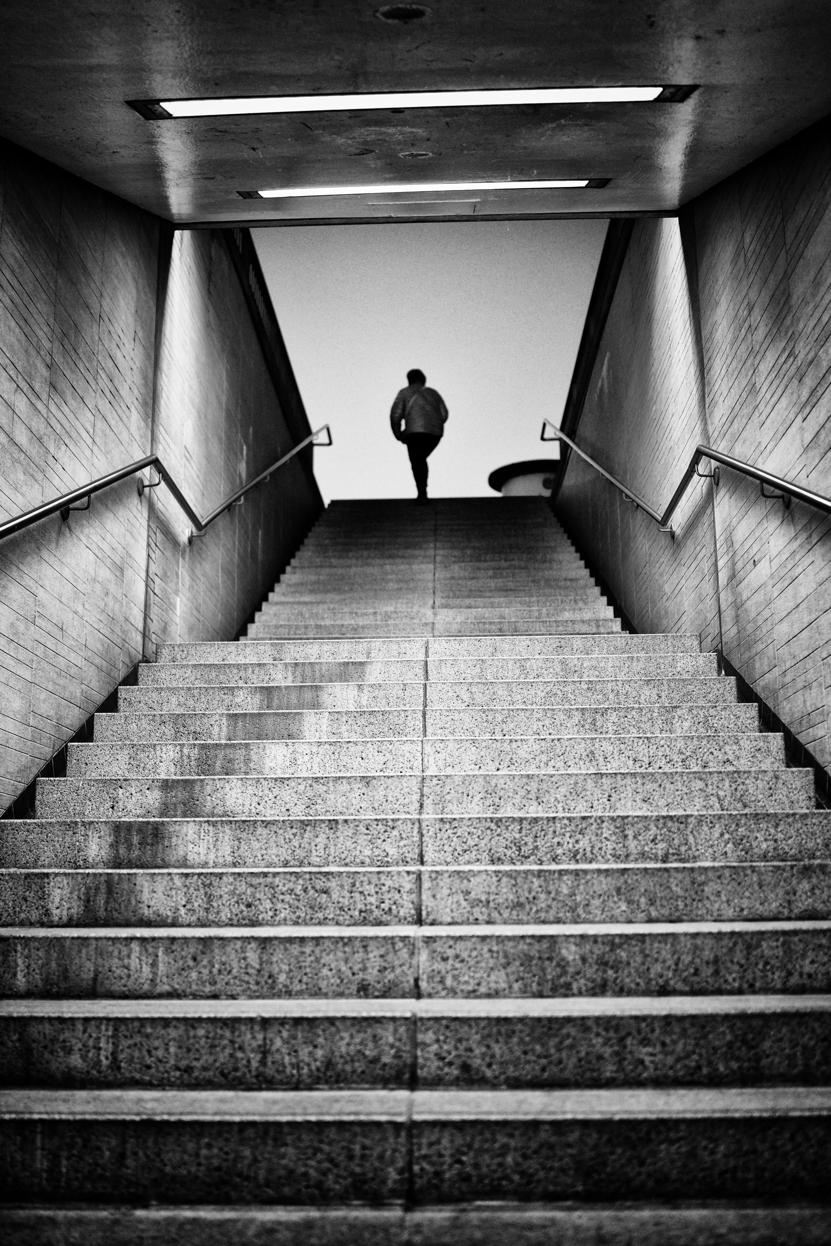Person an Treppenzugang, schwarz-weiß