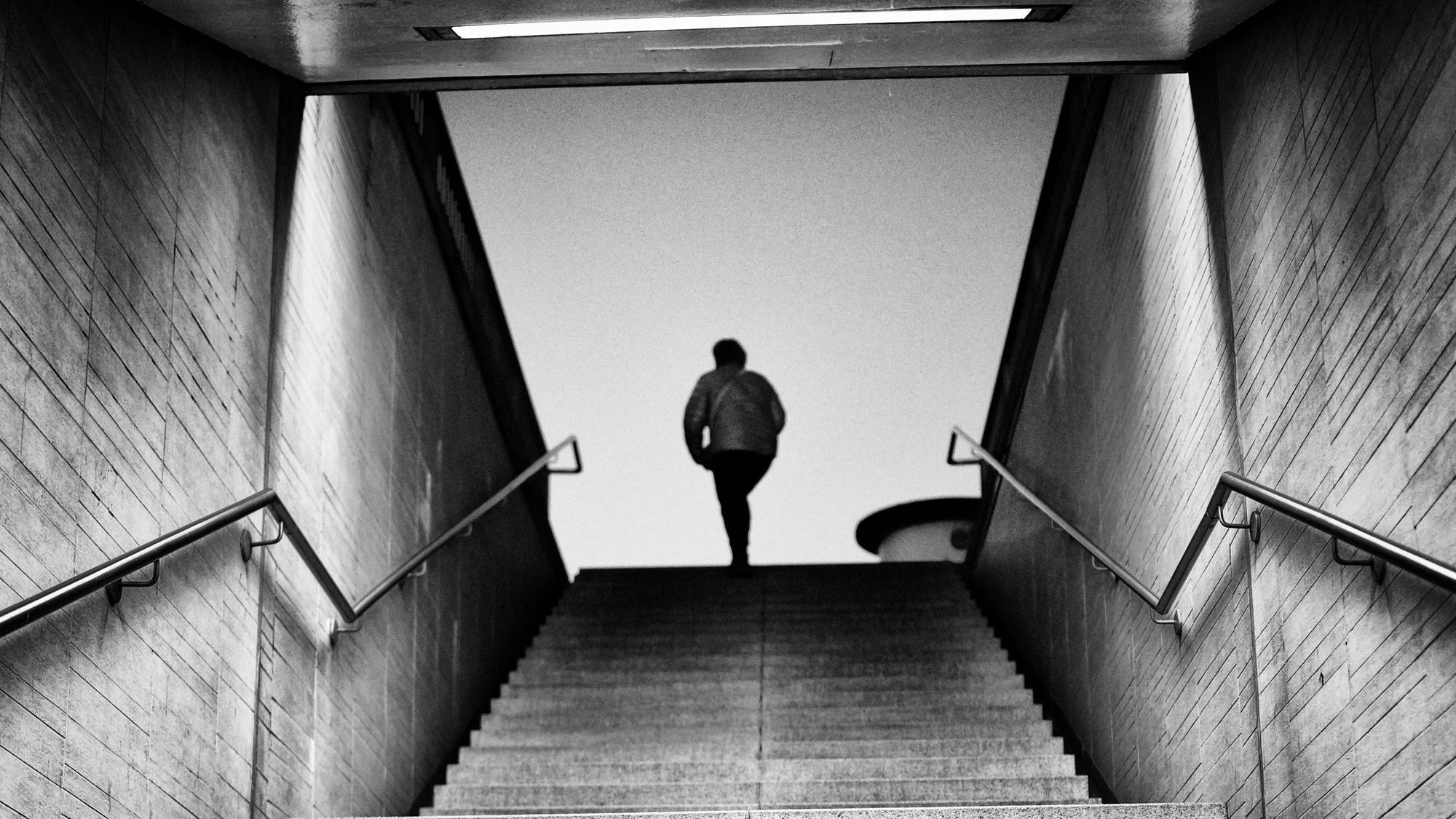 Person an Treppenzugang, schwarz-weiß