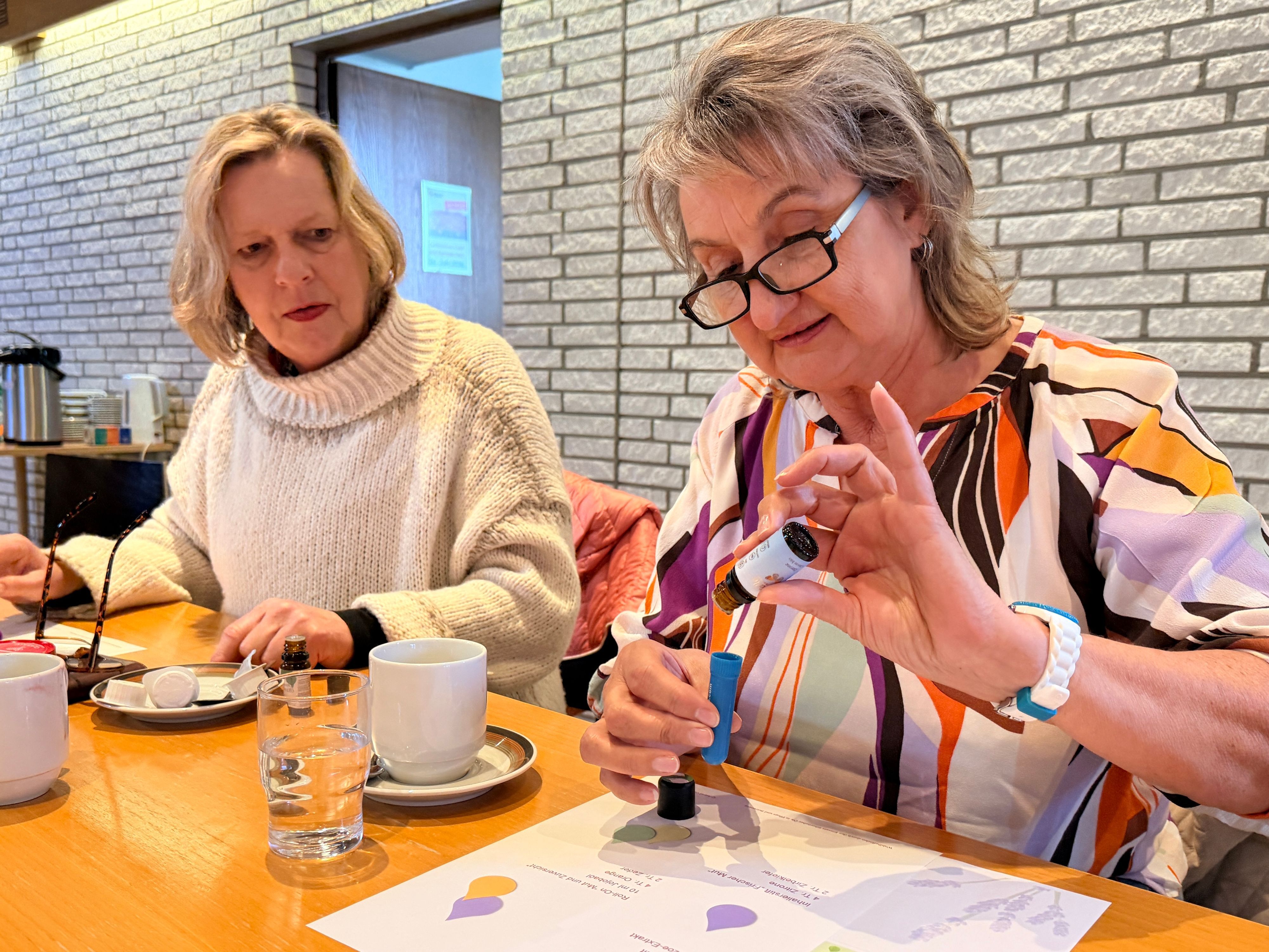 Zwei der Teilnehmerinnen zählen konzentriert die Tropfen des Öls für den Inhalierstift.