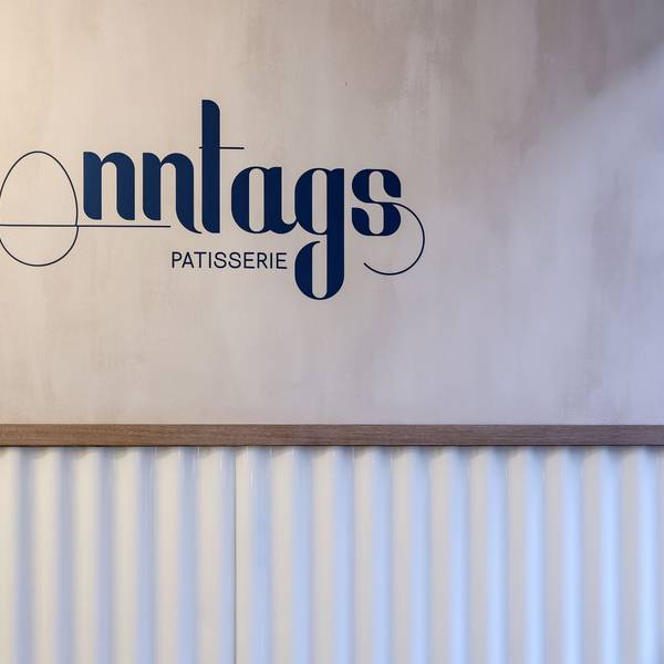 Logo von der Sonntags Patisserie auf der Wand im Café.