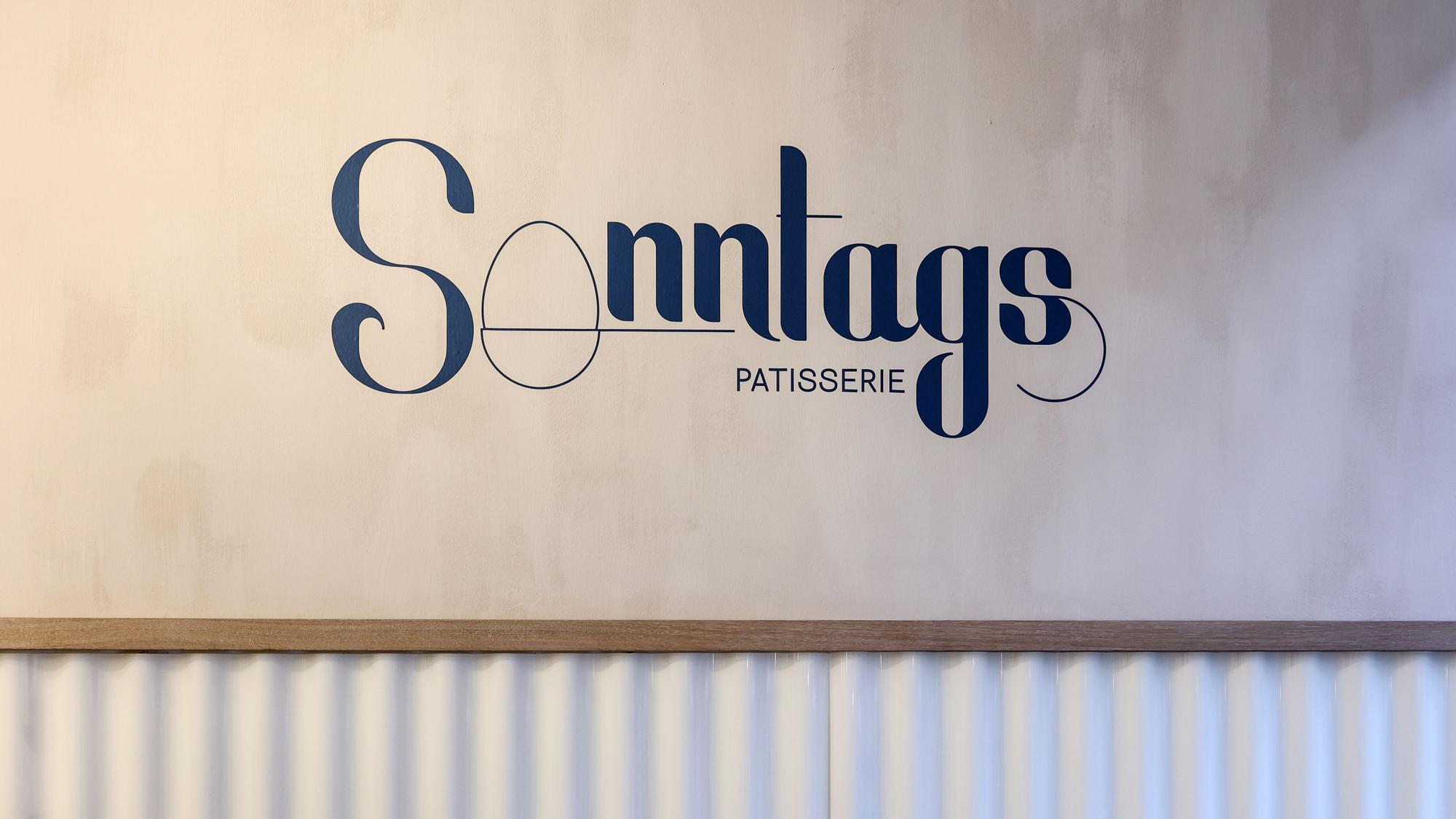 Logo von der Sonntags Patisserie auf der Wand im Café.
