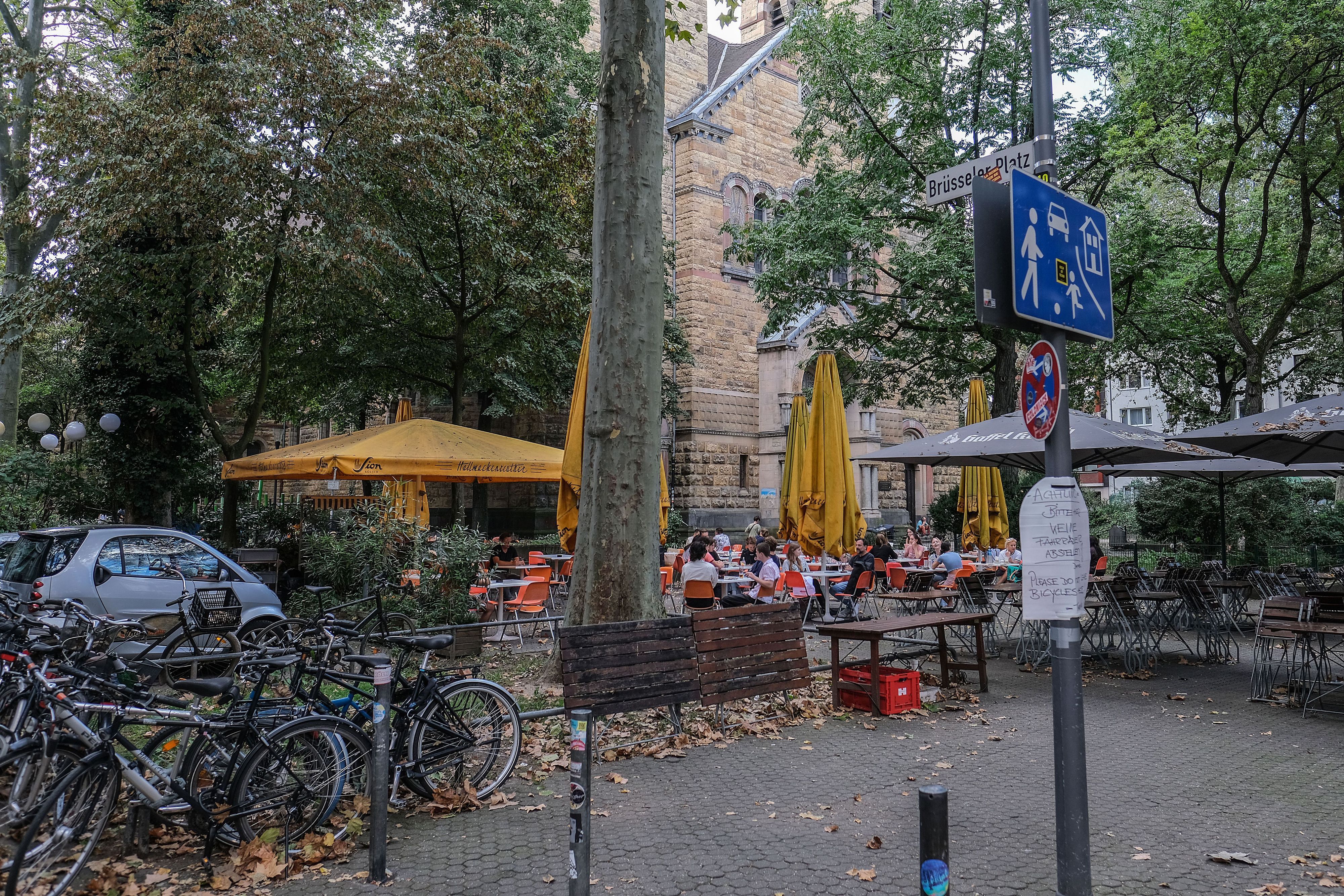 ARCHIV - 18.09.2023, Nordrhein-Westfalen, Köln: Menschen sitzen am Brüsseler Platz in einem Straßencafé. (zu dpa: «Köln vor Zwangsgeld wegen Partylärm auf Brüsseler Platz») Foto: Oliver Berg/dpa - ACHTUNG: Verwendung nur im vollen Format +++ dpa-Bildfunk +++