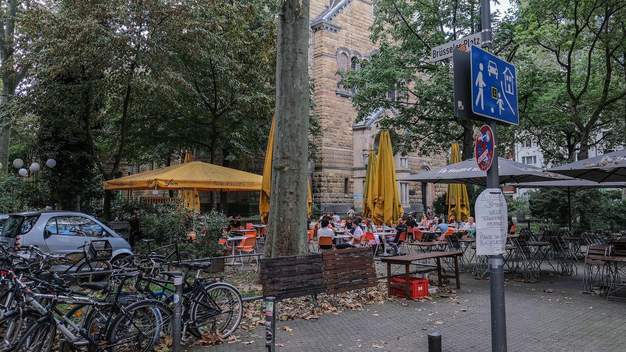 ARCHIV - 18.09.2023, Nordrhein-Westfalen, Köln: Menschen sitzen am Brüsseler Platz in einem Straßencafé. (zu dpa: «Köln vor Zwangsgeld wegen Partylärm auf Brüsseler Platz») Foto: Oliver Berg/dpa - ACHTUNG: Verwendung nur im vollen Format +++ dpa-Bildfunk +++