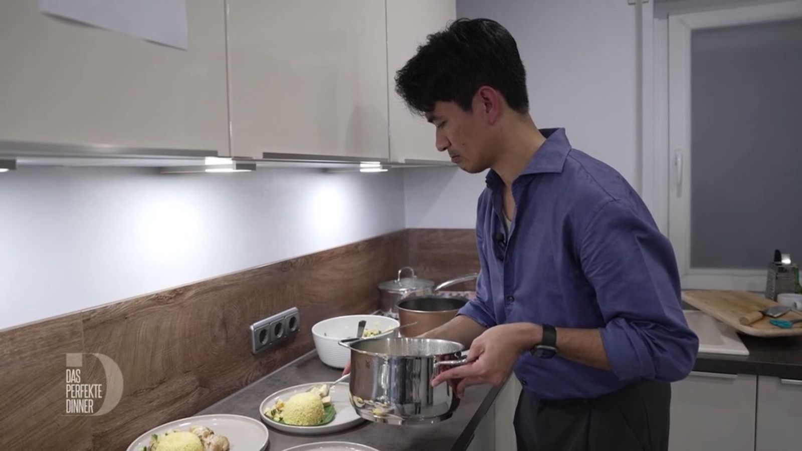 Konzentriert richtet Ragil seine Hauptspeise an: Hähnchencurry mit Ananas-Gurken-Salat und Reis.
 (Bild: RTL)