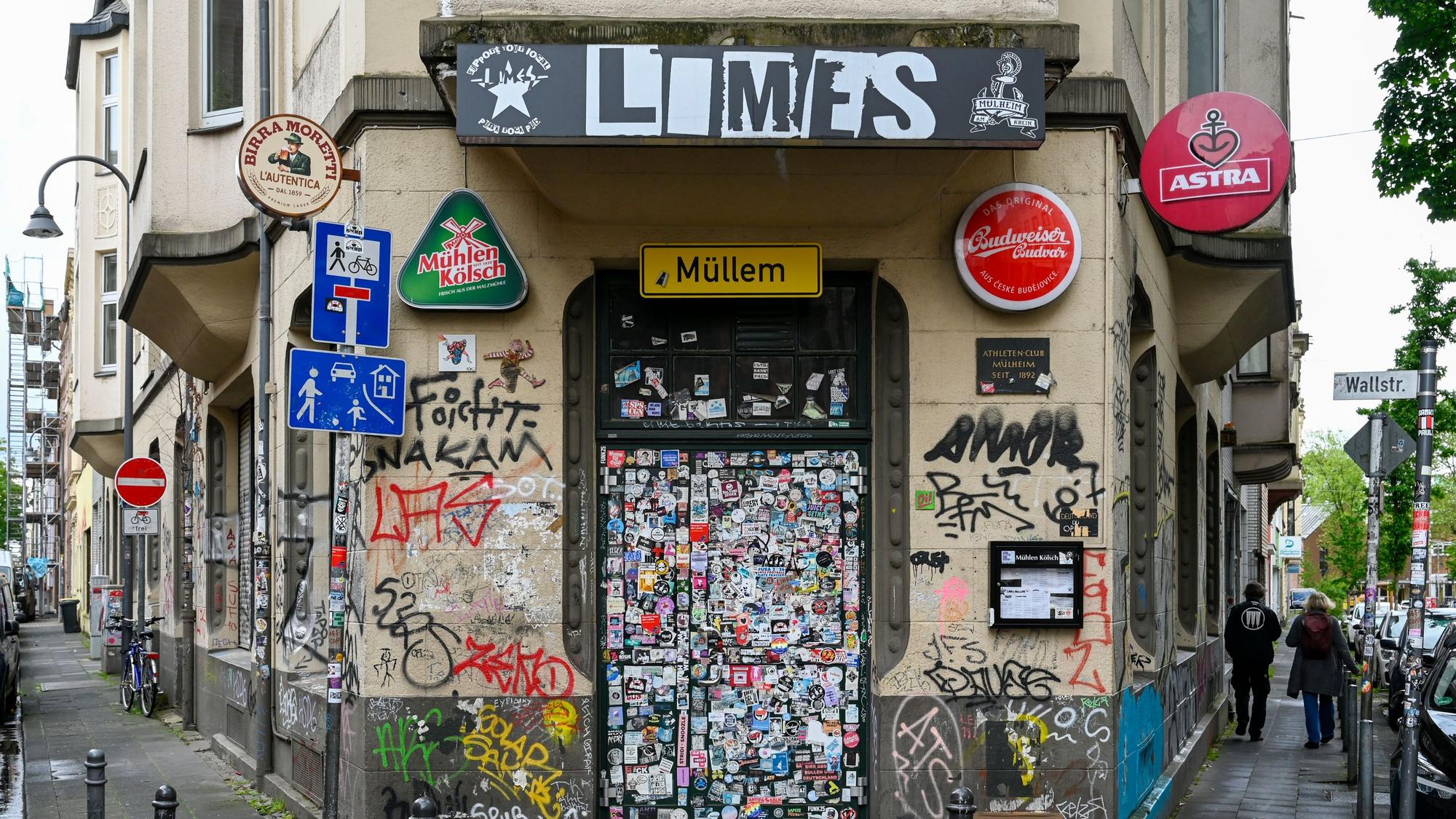 Eine Eckkneipe mit über und über mit Aufklebern bedeckter Eingangstür.