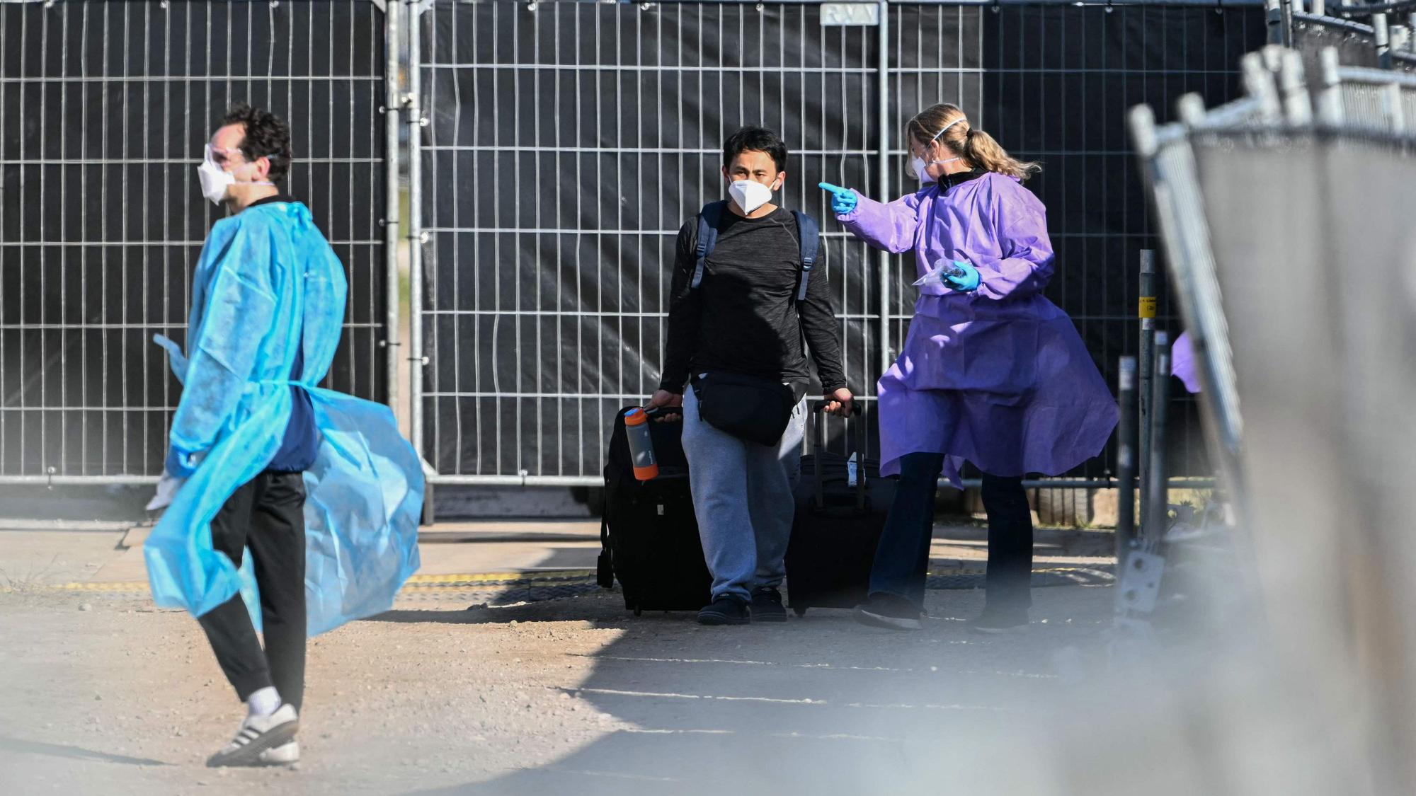 Ein Mann mit Atemschutzmaske verlässt in Begleitung von medizinischem Personal das von einem Hantavirus-Ausbruch betroffene niederländische Kreuzfahrtschiff „Hondius“ im Hafen von Rotterdam.