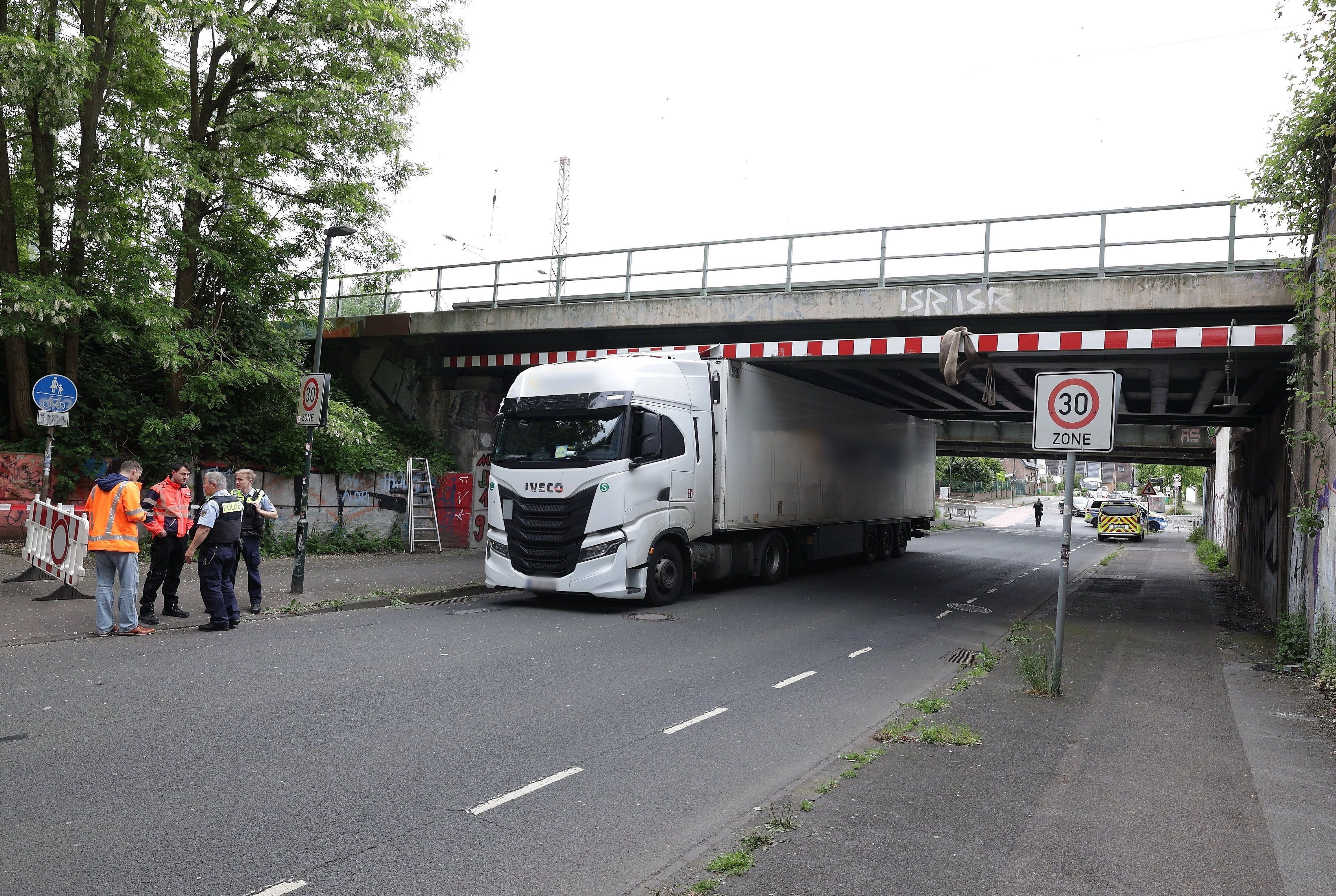 19.05.2026, Nordrhein-Westfalen, Düsseldorf: Ein Lkw steckt unter eine Eisenbahnbrücke fest. Zahlreiche Bahnreisende von und nach Düsseldorf sowie auf der verkehrsreichen Strecke zwischen Düsseldorf und Köln müssen nach dem Lkw-Unfall in einer Unterführung mit Umleitungen und Ausfällen rechnen. Foto: David Young/dpa - ACHTUNG: Kennzeichen und Kennungen wurden rechtlichen Gründen gepixelt +++ dpa-Bildfunk +++