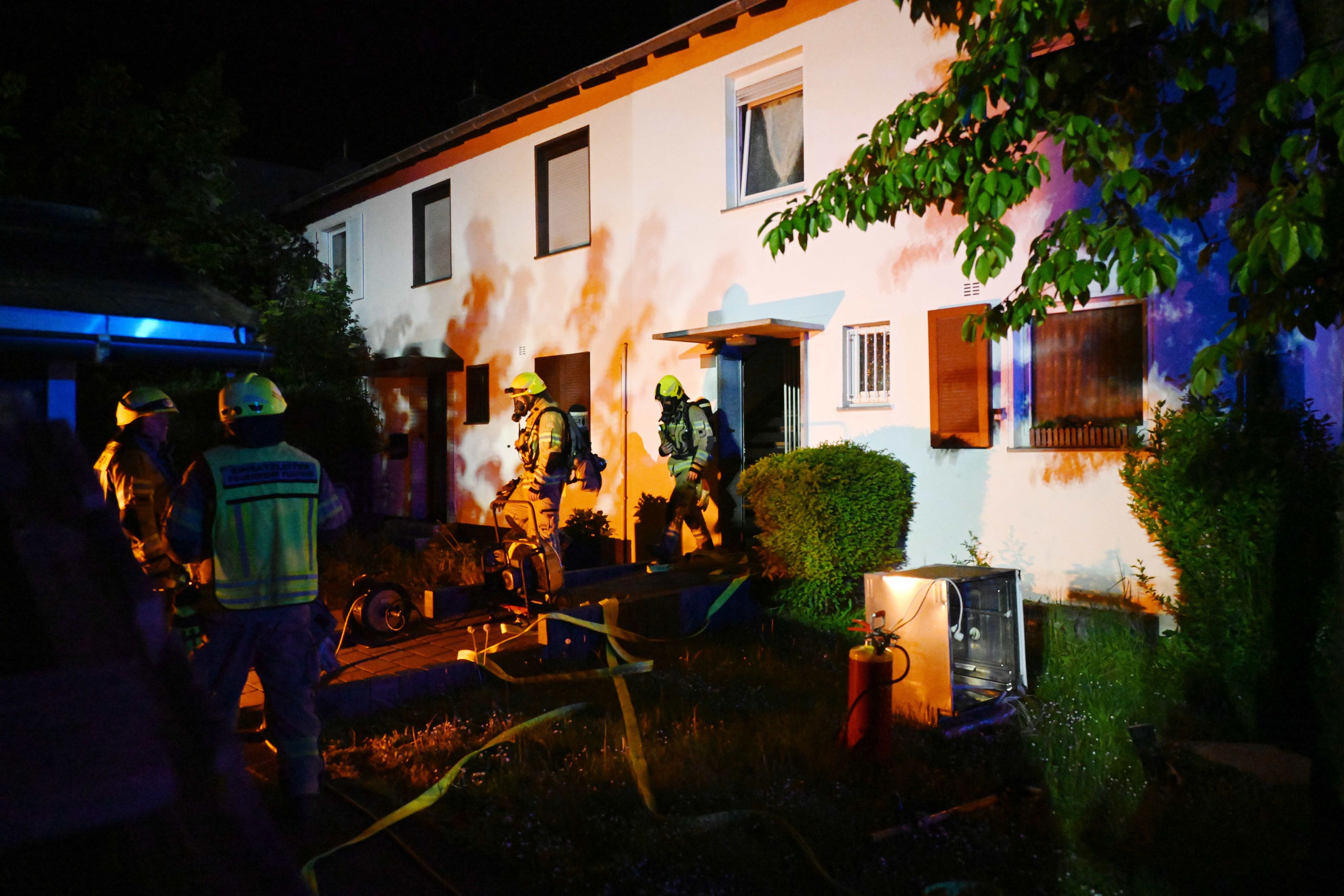 Das Bild zeigt Feuerwehrleute von einem Haus.