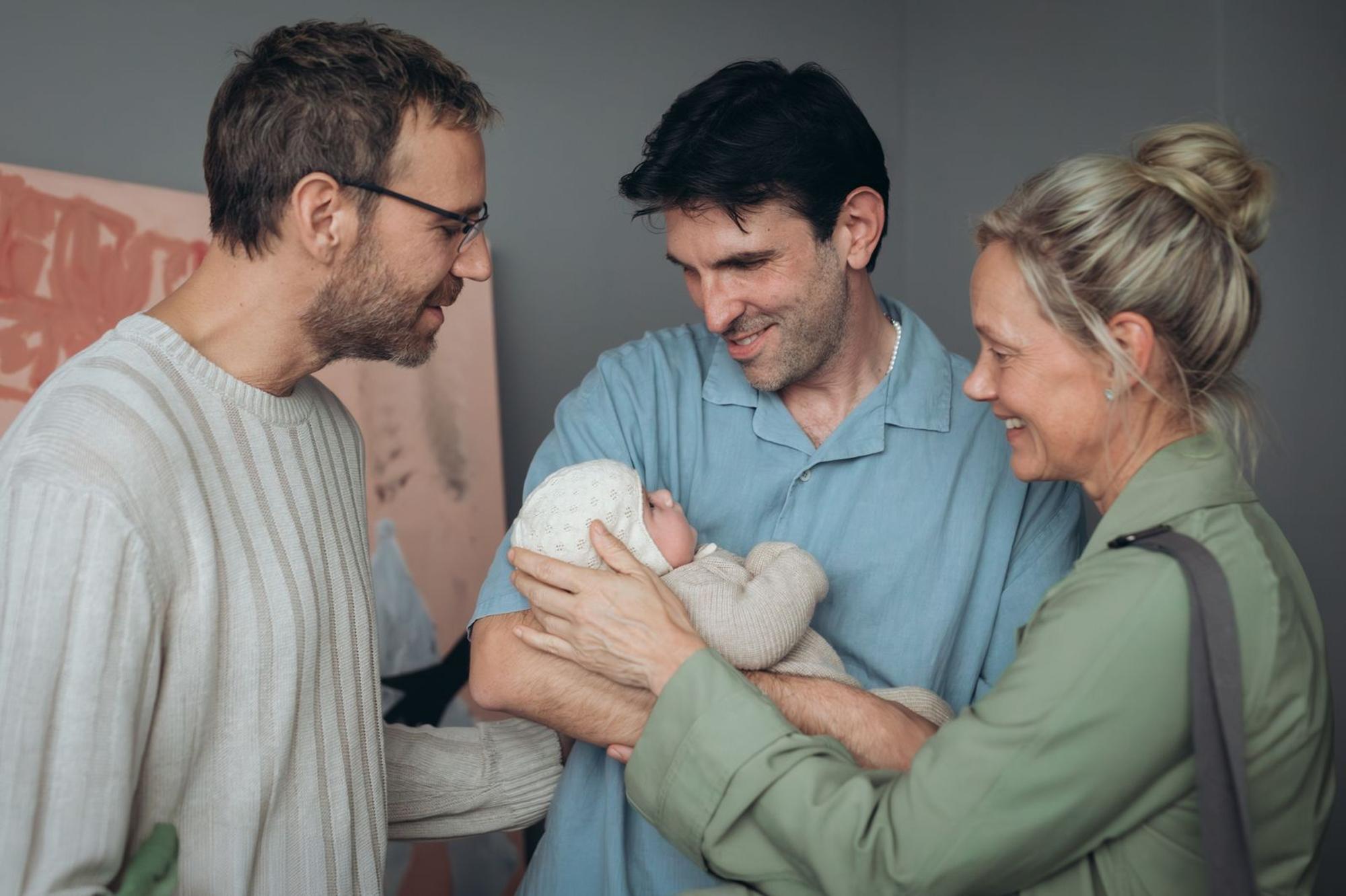 Als Valentin (Knut Berger, links) und Nic (Fabian Stumm) Anna (Anna Schudt) bitten, die Nachversorgung ihres von einer Leihmutter in den USA ausgetragenen Babys zu übernehmen, ist sie zunächst voller Vorurteile. Doch dann erkennt sie, dass das die einzige Option für das liebende Elternpaar war. (Bild: ZDF/Andrea Hansen)